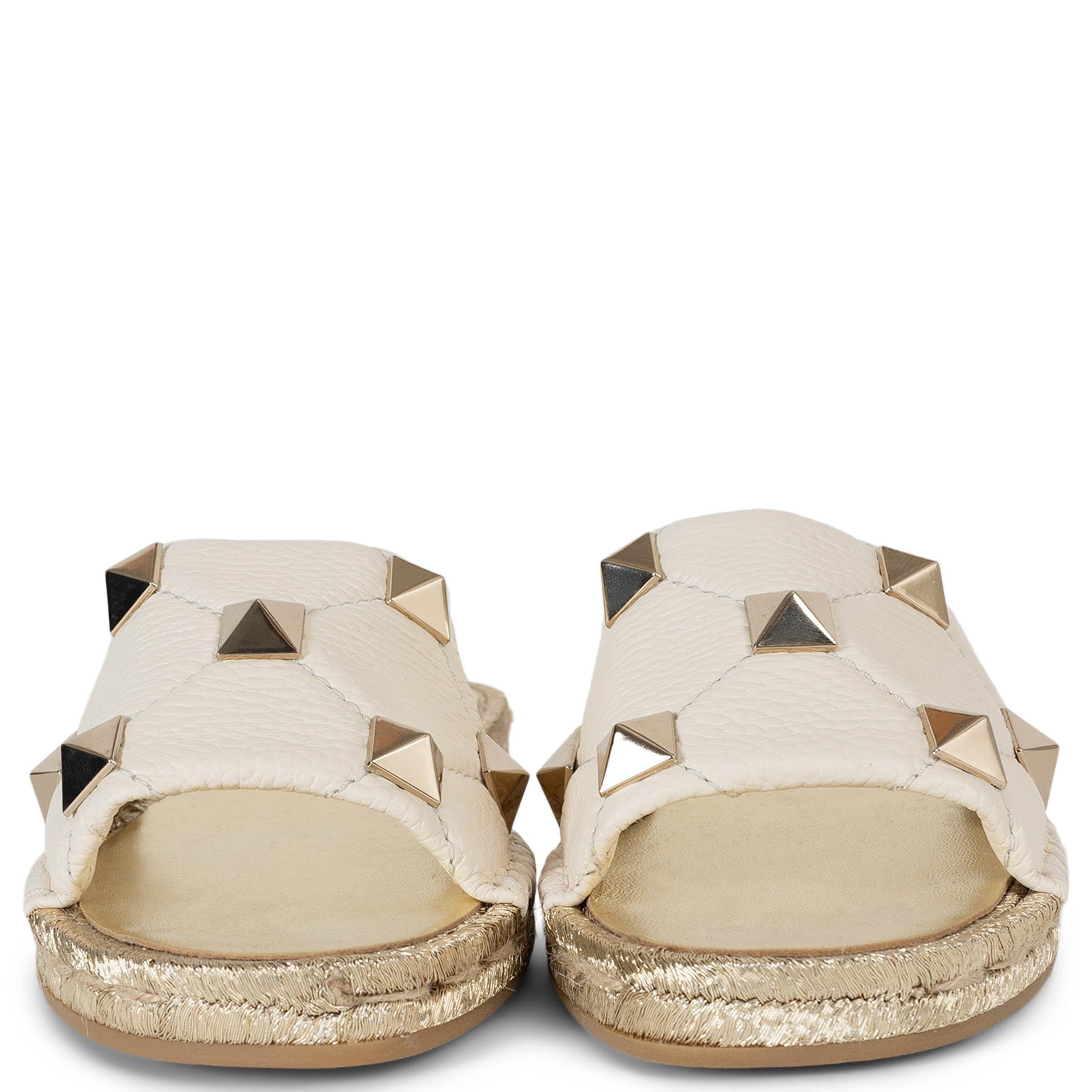 Ces sandales à glissière en cuir crème à clous romains 100% authentiques de Valentino incarnent une sophistication sans effort avec une pointe d'audace. Agrémentées de clous pyramidaux plaqués palladium, elles présentent des orteils ouverts et