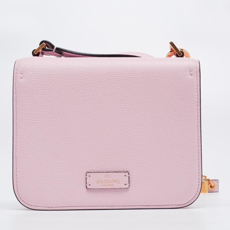 This VSling shoulder bag from Valentino emerges as a skillfully created, exquisite piece from the House of Valentino. Flaunting the VLogo on the frontal flap and an exterior made from light pink grained leather, this bag assures sparks of
