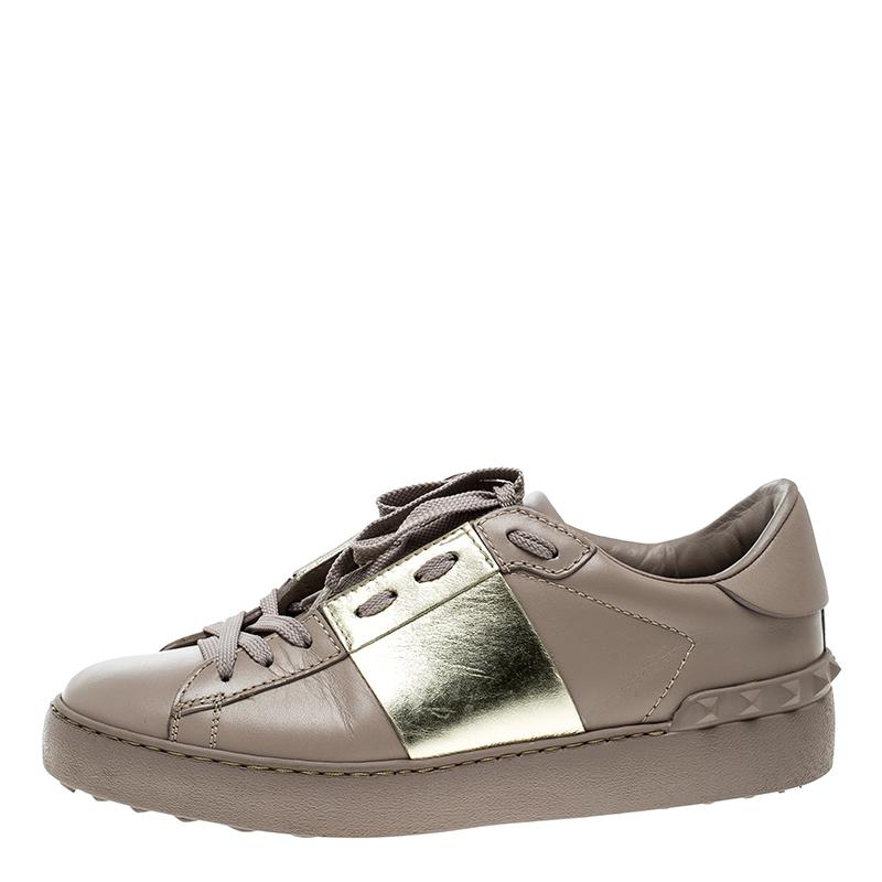 Built to provide comfort, this pair of Valentino sneakers are trendy and stylish. They've been crafted from leather in a dreamy lilac hue and styled with a band of gold. A lace-up vamp, label-embossed tongue, and the signature Rockstud detailing on