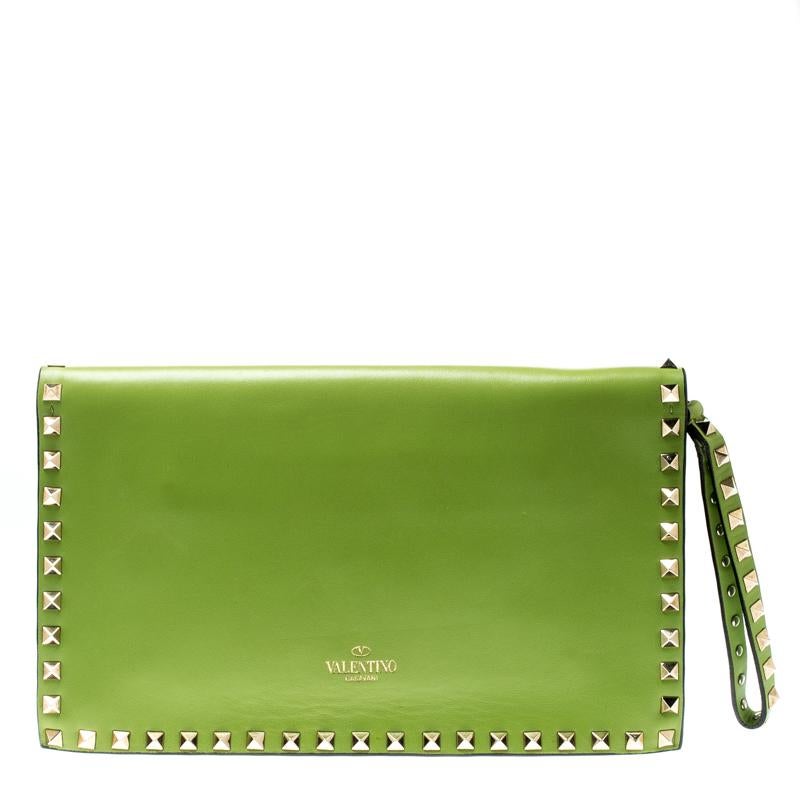 This Valentino leather wristlet clutch is a statement piece to add to your closet. Crafted with lime green leather and lined with Rockstuds on the edges, handslot and wristlet, this clutch is high on style. The interior is lined with leather and has