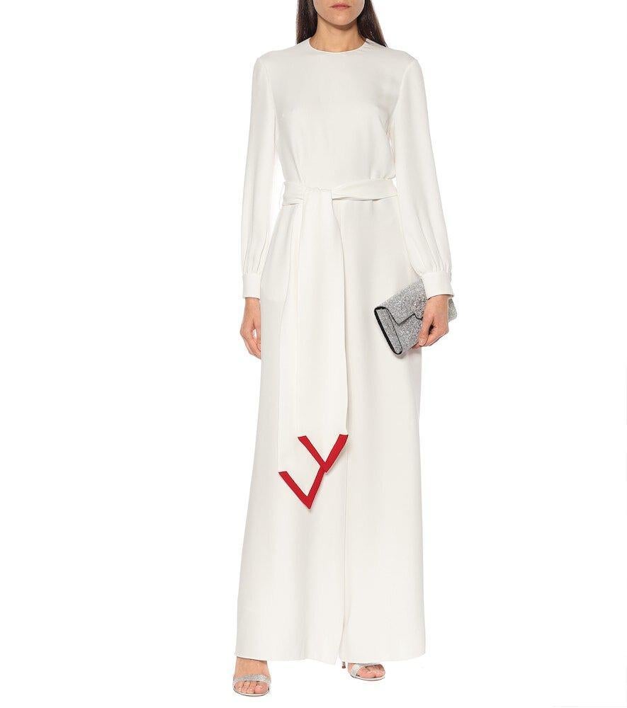 Valentino's V emblem stands out in high-contrast red against the white silk fabrication of this jumpsuit.
Round neckline
Long sleeves
Concealed back hook and zip closure
Concealed button cuffs
Includes detachable, adjustable belt with contrasting
