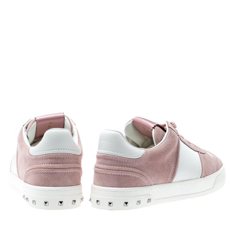 These Flycrew sneakers from the house of Valentino have been designed from Bianco suede and leather body. It comes with lace-ups and is set on a subtly raised sole. It is detailed with the signature pyramid studs from the house. Style your with