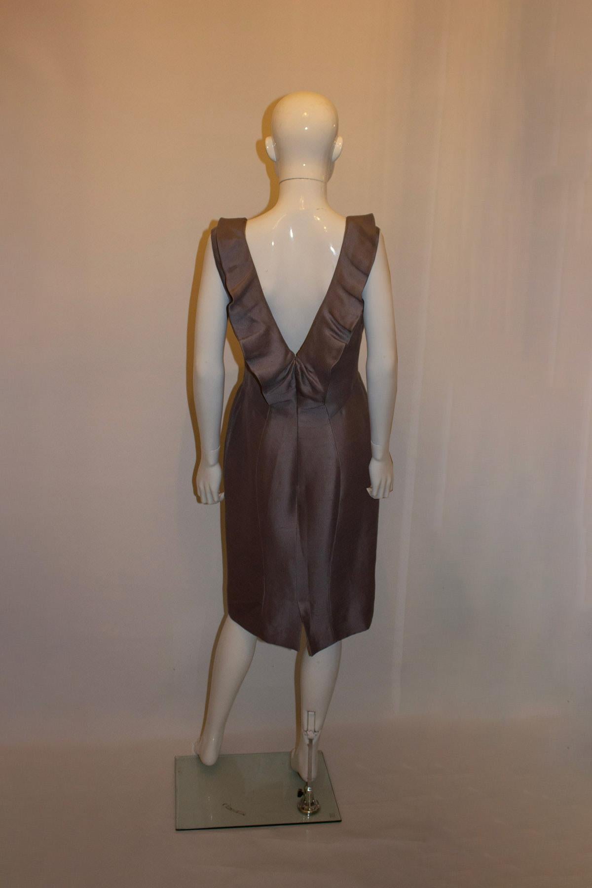 A chic cocktail dress by Valentino ( main line). The dress is in a pretty shade of dove grey and 100 % silk. It is slightly off the shoulders with a modesty patch that could be removed. It has a back zip opening with attractive gathering at the