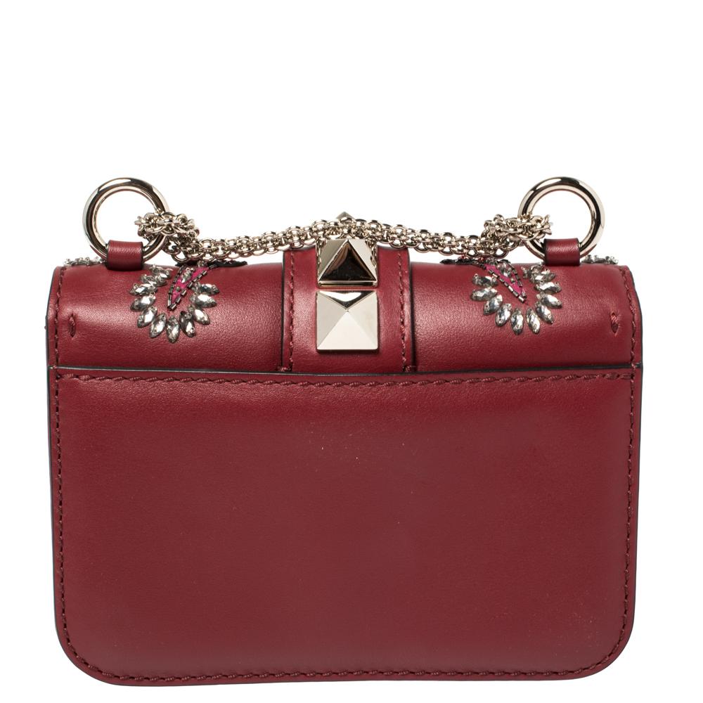 Valentino’s famed Glam Lock bag is taken to glamorous new heights. This marron leather style comes adorned with a 'Love Blade' design featuring heart motifs, bead and crystal embellishments set into the top flap and front panel and finished with a