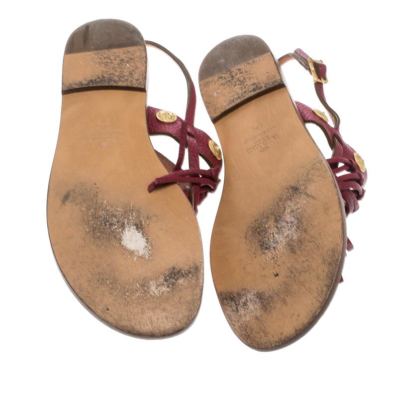 Valentino never fails to impress and manages to win our hearts every time! These maroon sandals are crafted from leather and feature an open toe silhouette. They flaunt a thong design with a fringe and gold-tone coin detailed vamp strap that looks
