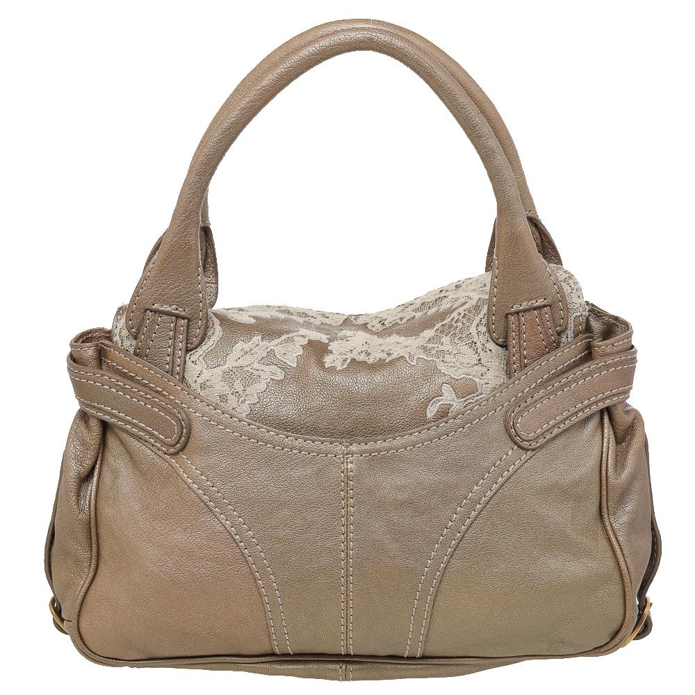 This lovely satchel by Valentino will hold all of your daily belongings in style. Crafted from metallic leather and laid with lace, this bag features two handles, gold-tone hardware, and a spacious canvas interior.

Includes: Original Dustbag
