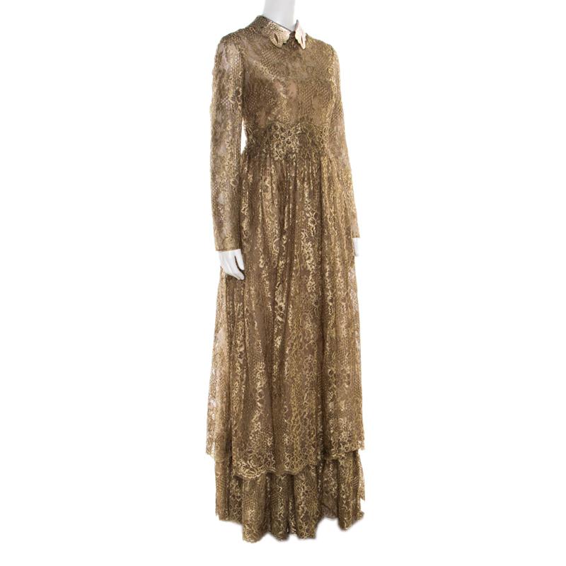Feel royal in this exquisite gown from the house of Valentino. Ideal for grand nights, this metallic gold piece, designed with floral lace, a studded leather collar and tiered skirt, can be worn with open toe sandals.

Includes: The Luxury Closet