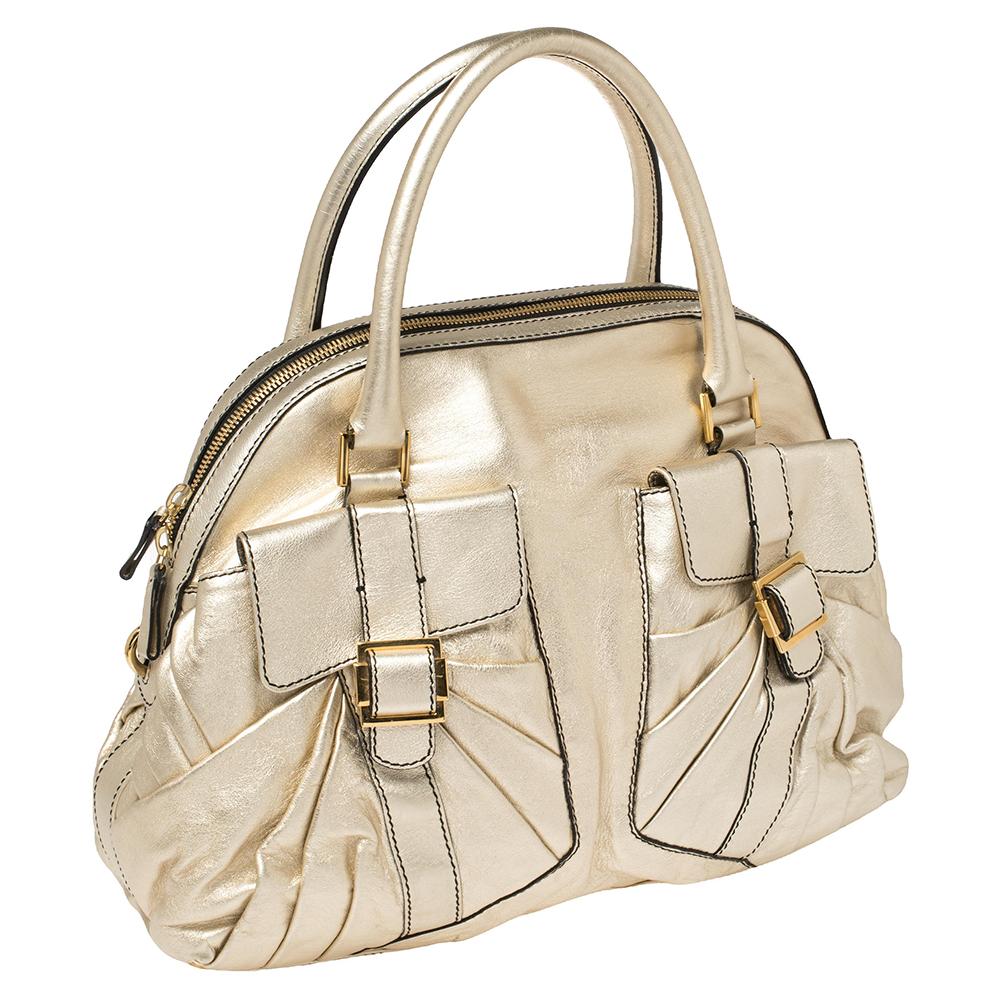 Every woman needs a bag that is pretty and functional, just like this satchel from Valentino. Crafted from metallic gold leather, it has been styled with two gathered buckle pockets on the front and dual handles. It has a top zip closure and opens