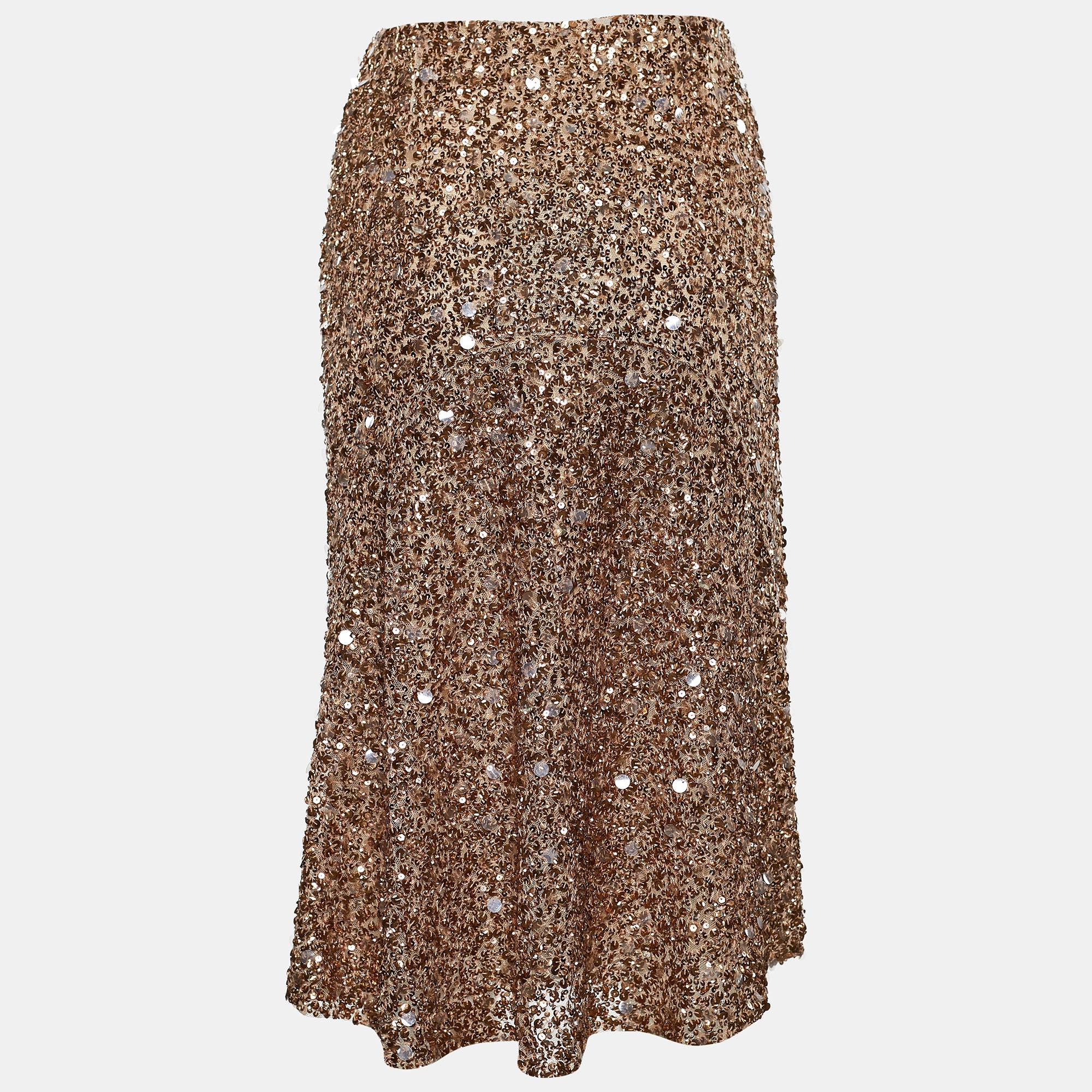 With its glittery appearance and party vibes, this fabulous Valentino skirt will surely make heads turn! Covered in metallic-gold sequin embellishments, this skirt has a knee-length silhouette that will help your ensemble shine all night! It is