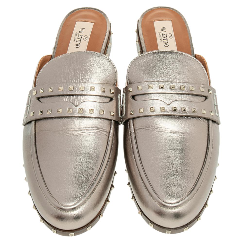 Opt for a unique style this season with these stunning Valentino flat mules. They are crafted from metallic grey leather and detailed with the label's signature pyramid studs on the vamps and base. Low heels are added to the pair for extra