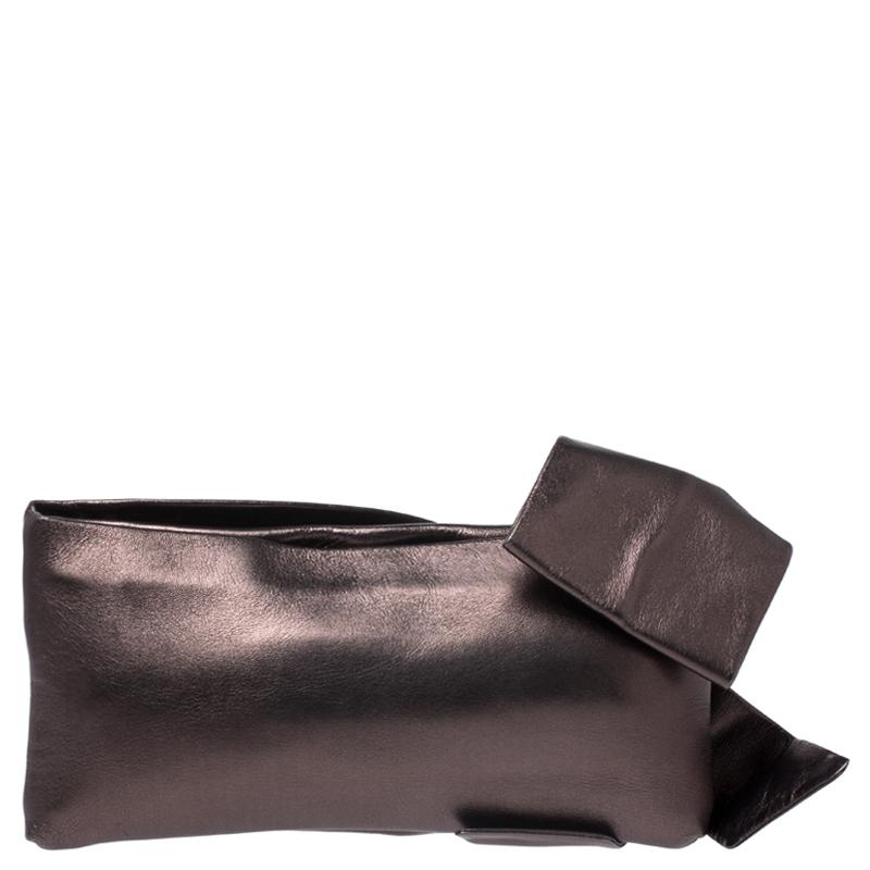 This clutch by Valentino is what you would carry on an evening out. The metallic leather exterior is simply detailed with a lovely oversized bow and a top zip closure. The satin interior will easily hold your little essentials.

Includes: The Luxury