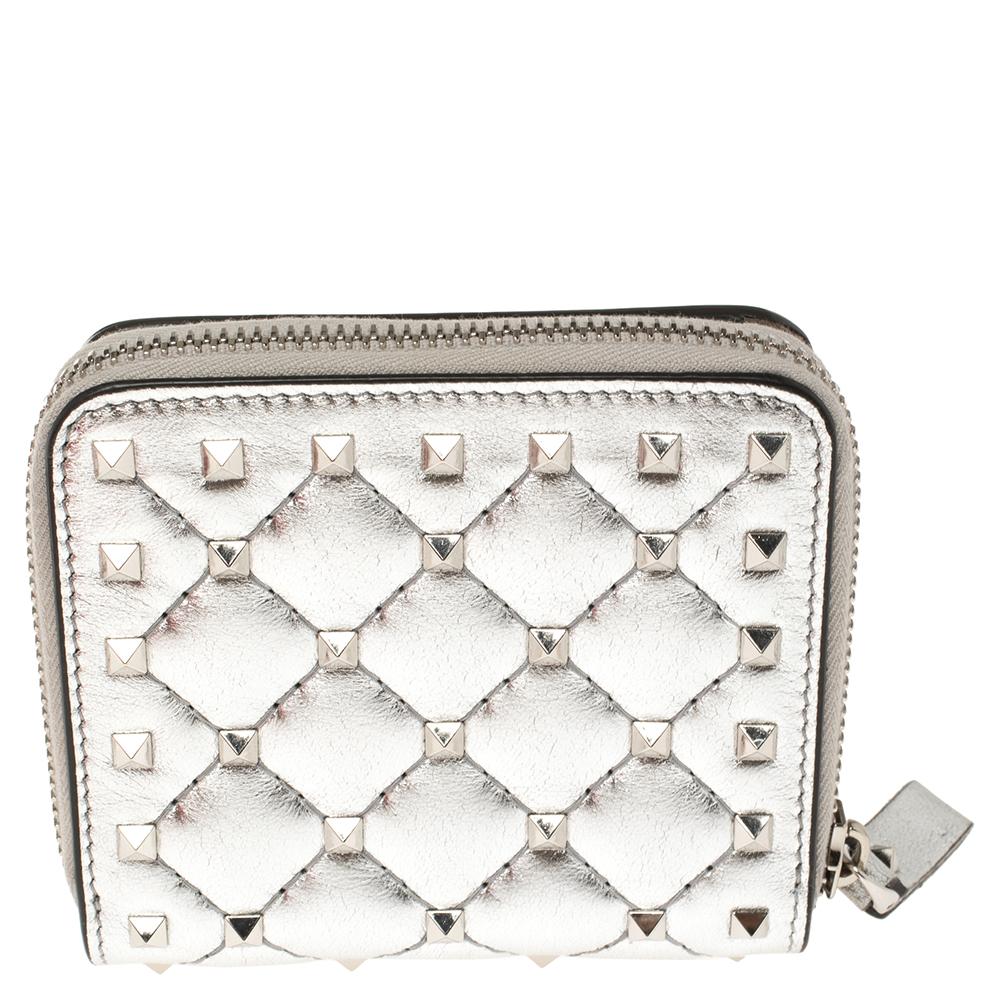 Crafted in Italy, this Valentino wallet is made of quality leather and comes in a lovely shade of metallic silver. It has signature studs on the quilted exterior and a zip-around closure that reveals a leather & fabric interior for your