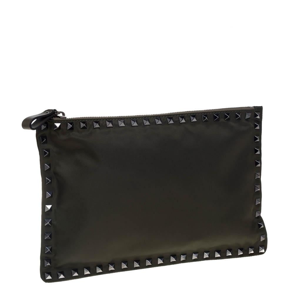 Clean, simple, and well-made, this military green clutch by Valentino speaks of chic style in a minimal way. Crafted from nylon, the flat clutch is adorned with the signature Rockstud accents on the exterior and its top zipper opens to a satin-lined