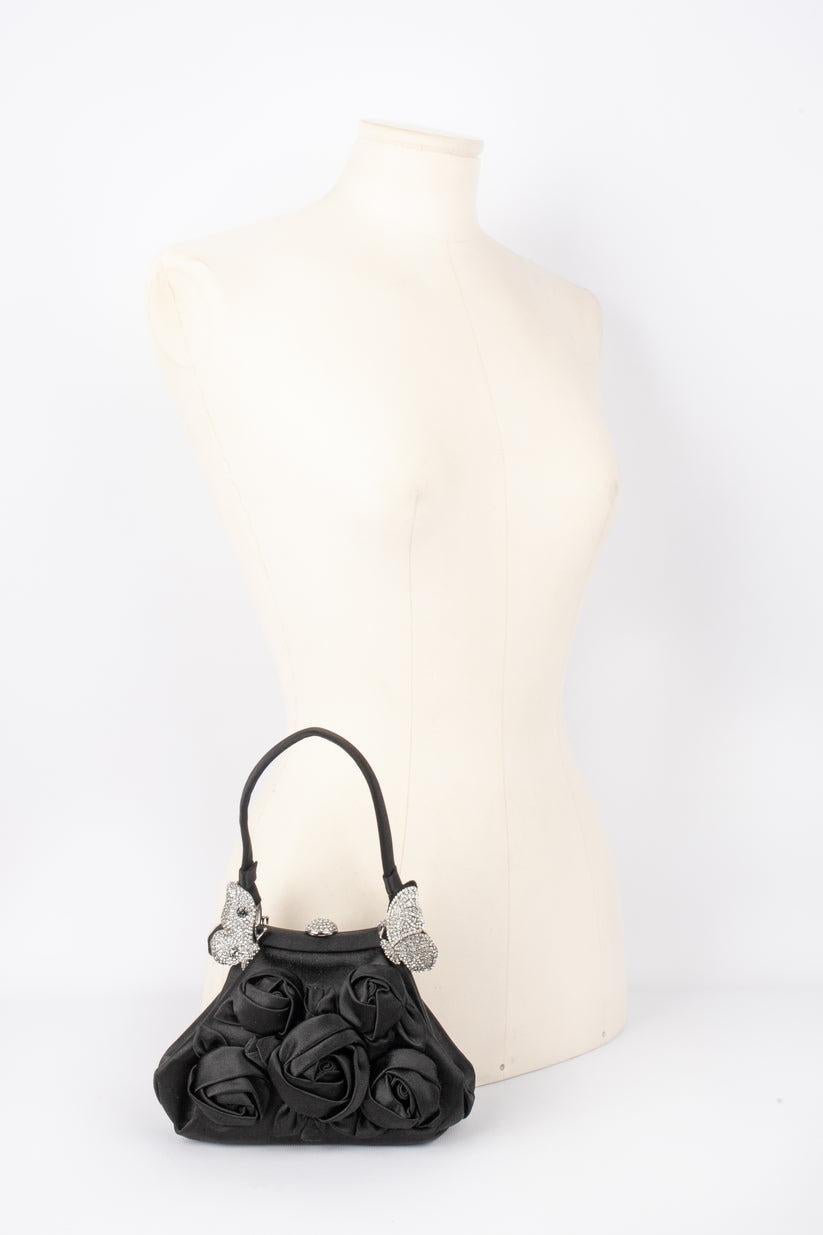 Valentino - (Made in Italy) Silvery metal and black silk minaudiere bag ornamented with rhinestones.

Additional information:
Condition: Very good condition
Dimensions: Height: 11 cm - Length: 19 cm - Depth: 5 cm - Handle length: 30 cm

Seller