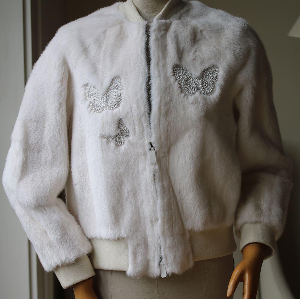 Valentino's bomber jacket is crafted of white luxurious mink fur. Made in Italy, this style is embellished with multicolored intricate beading in this season's iconic butterfly motif. Rib-knit stand shawl collar, cuffs, bottom band. Long sleeves.