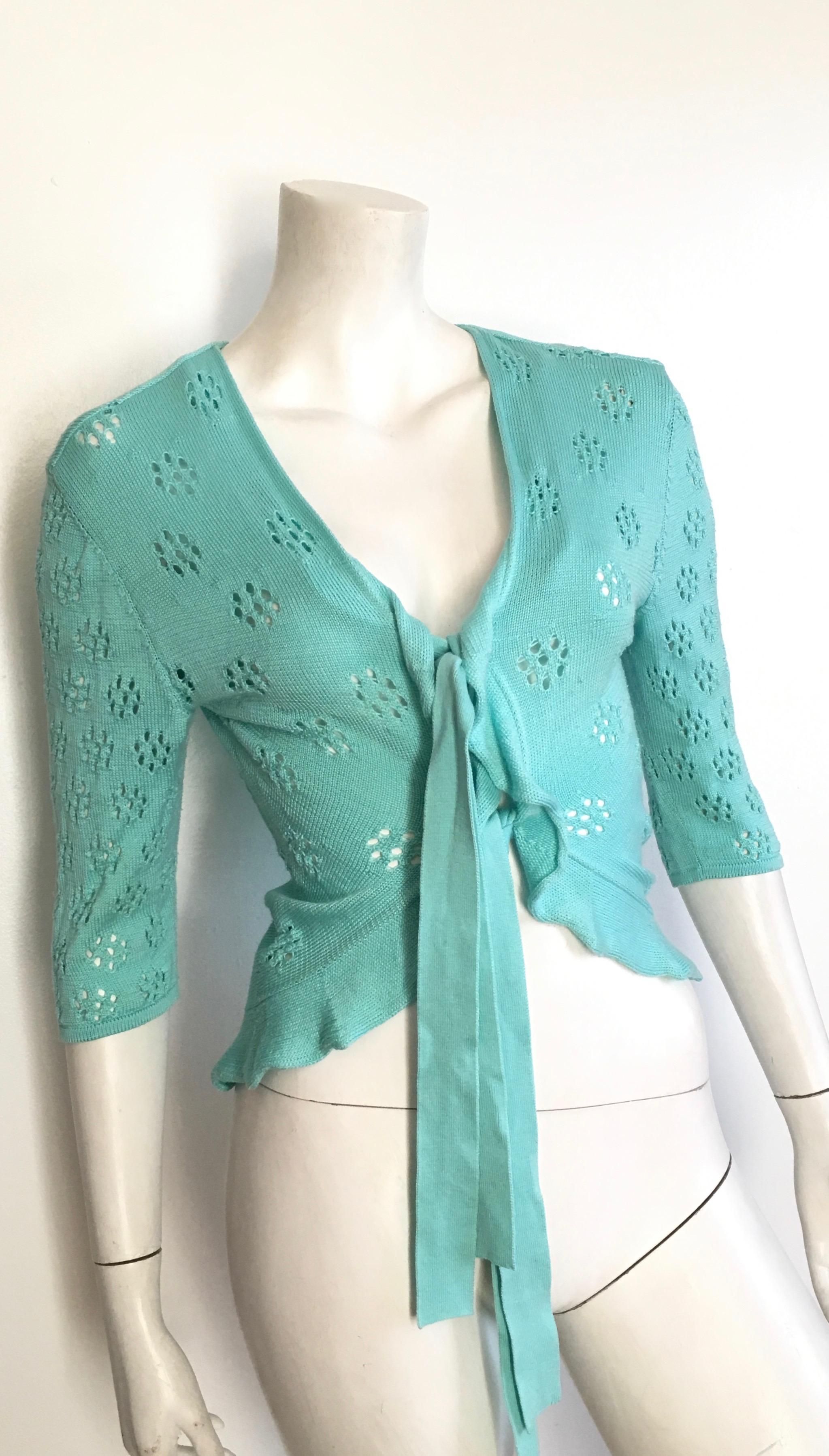 Valentino mint color cotton tie string front lightweight sweater is labeled a size Medium fits a size 4.  
Sweater is not lined.
Cute and very practical lightweight sweater that will work with just about anything in your wardrobe.  This would look