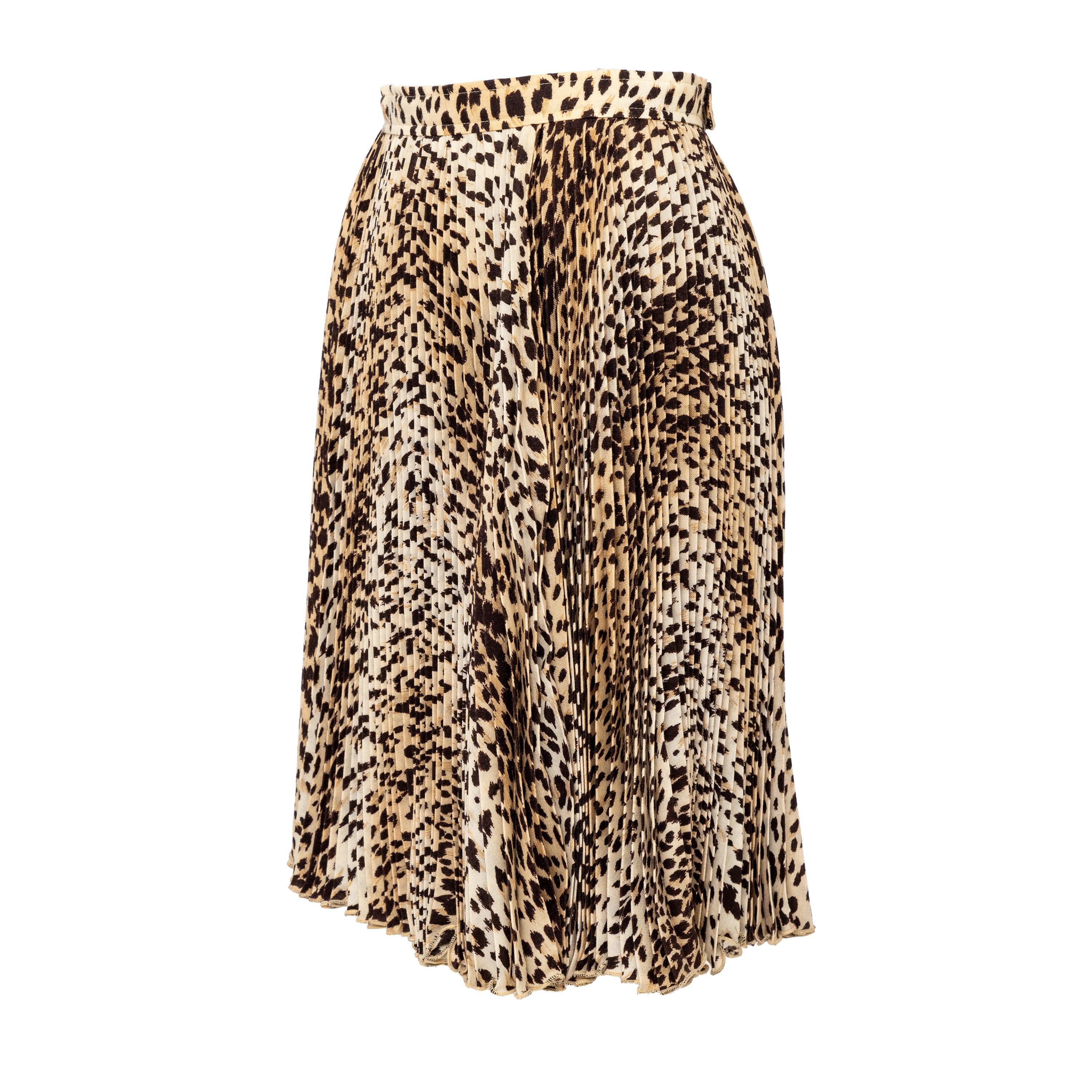 Cette jupe plissée Valentino du label V.I.I. allie la nostalgie des années 90 à un style moderne. Conçue en 100% laine, cette jupe midi présente un design plissé chic et un imprimé léopard audacieux, ajoutant une touche de férocité à votre