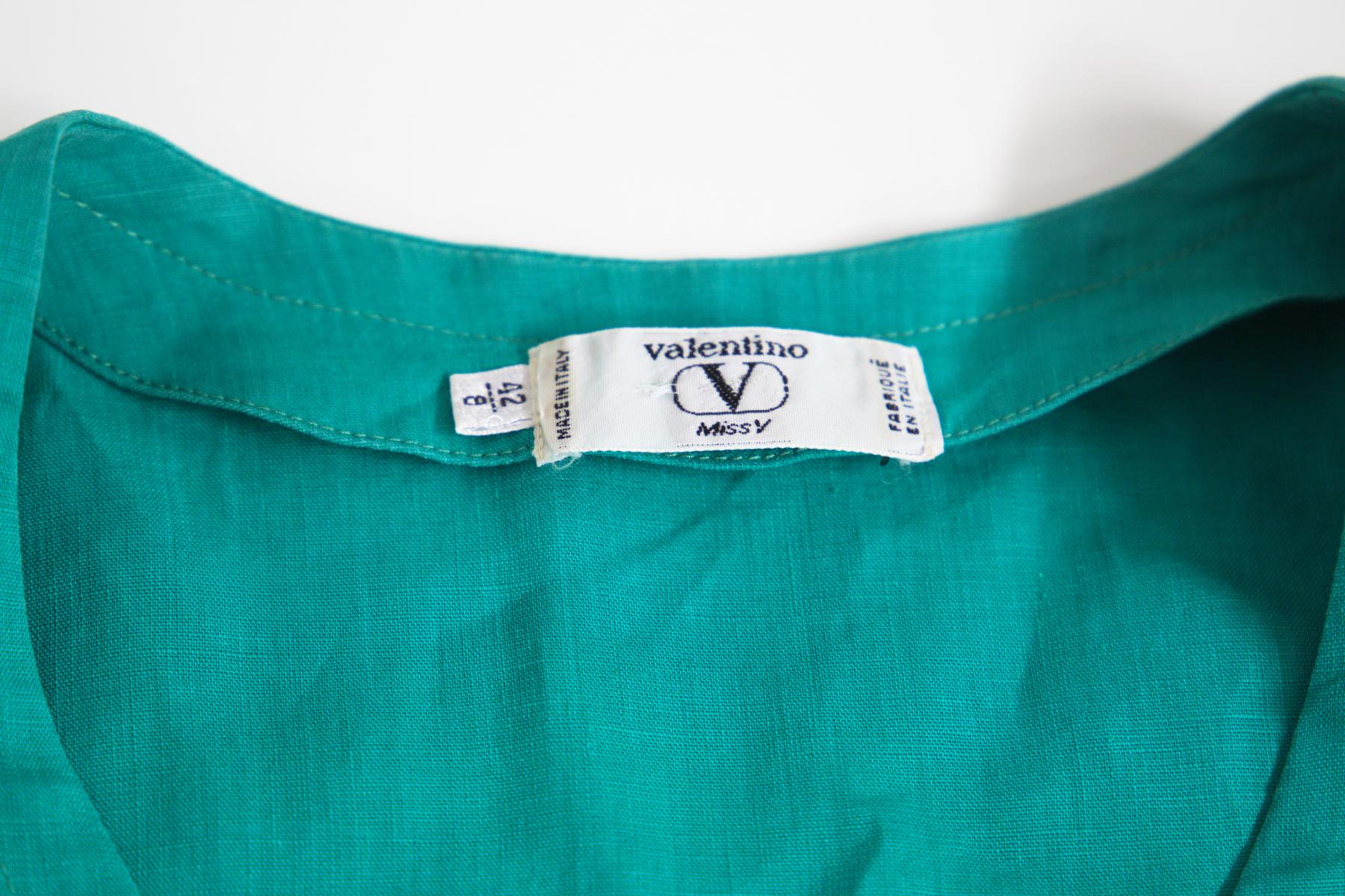 Attractive vintage linen suit by Valentino Miss V from the 1990s, made in Italy. ORIGINAL LABEL.
The suit consists of two pieces: jacket and skirt.
The jacket is short sleeved with a pronounced, yet composed, U-neckline. Completely in turquoise