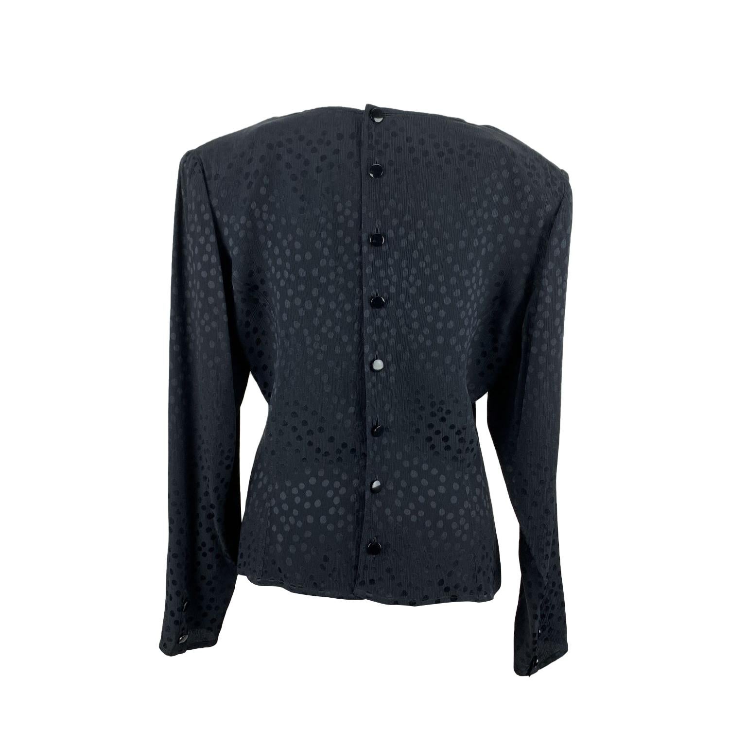 Valentino Miss V black wrap-style blouse. It features a v-neckline, long sleeve with shoulder pads and buttoned cuffs and button closure on the back. Composition tag is missing; it seems to be silk. Size: 46 IT, 12 (it should correspond to a MEDIUM
