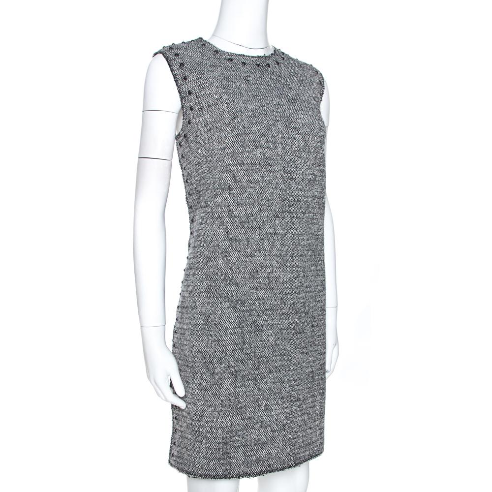 Perfect for formal occasions, this Valentino shift dress is a must-have. Crafted meticulously from 100% wool, this tweed dress comes with a pure silk lining. It features a monochromatic color scheme that is versatile and flattering. This sleeveless