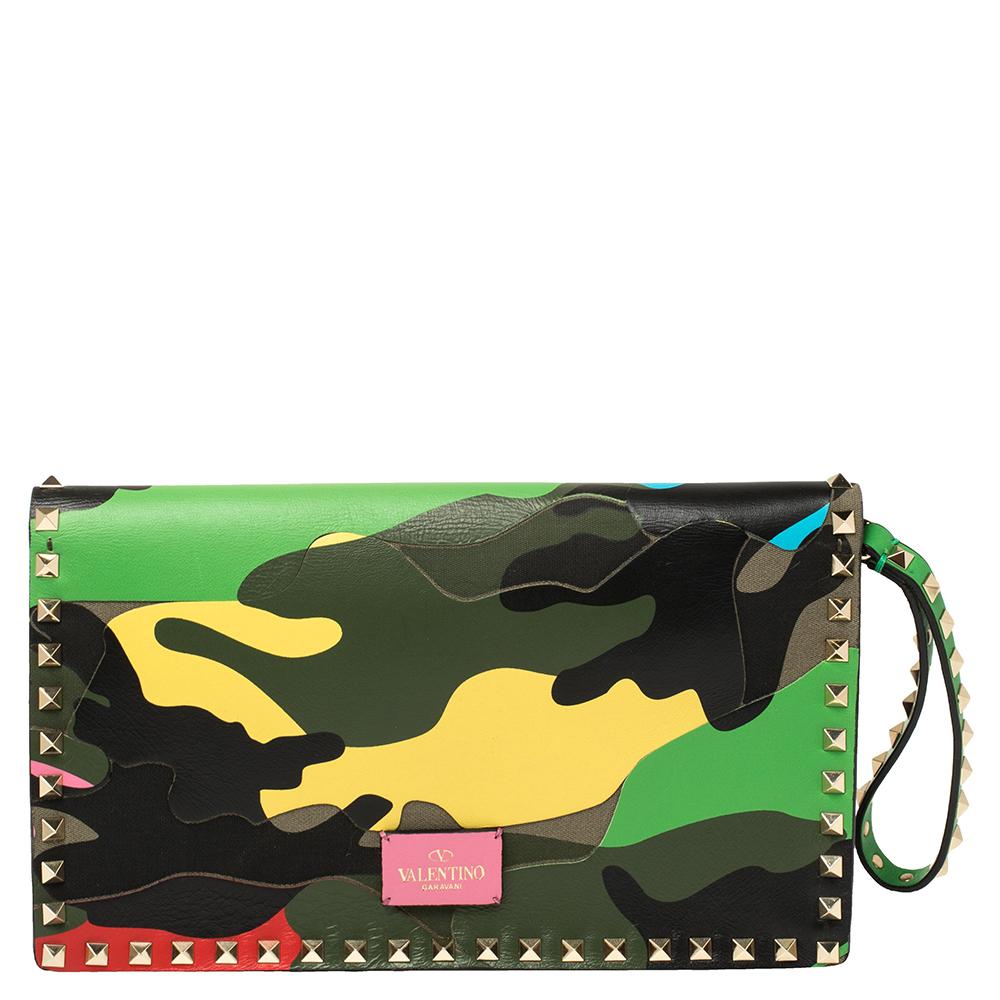 Very stylish and well-made, this multicolor camouflage clutch by Valentino speaks of chic style in a minimal way. Crafted from leather and canvas, the clutch is styled with a front tuck-in strap and adorned with the signature Rockstud accents on the