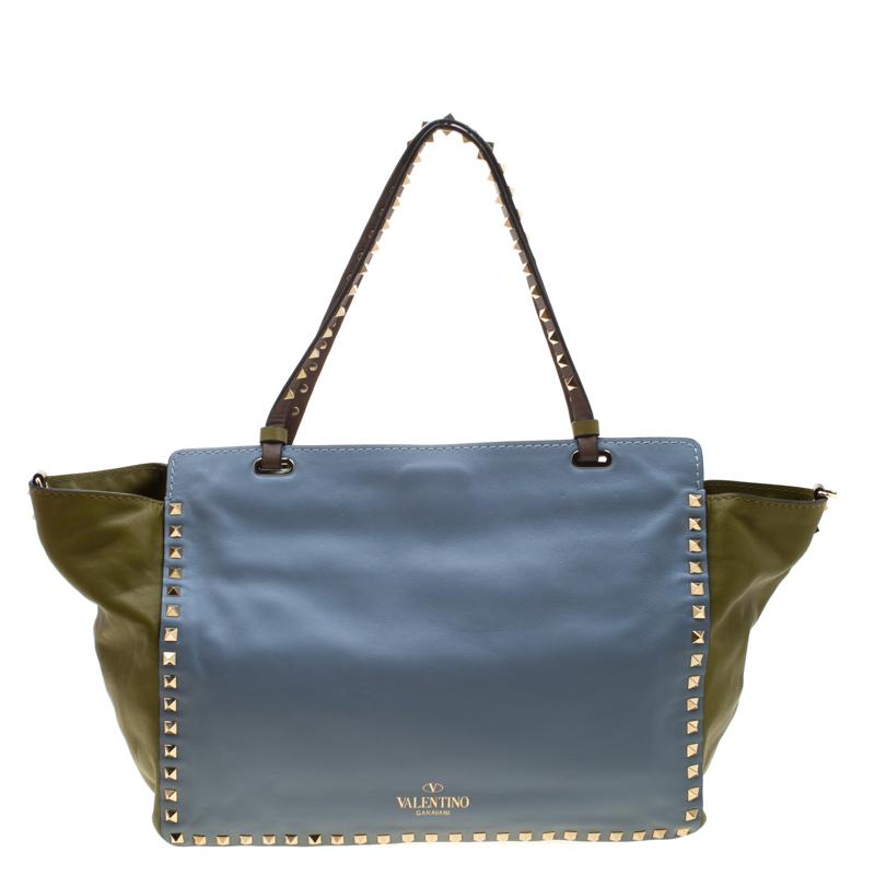 Valentino brings you this super-stylish tote that carries a design which will surely grab the attention of your onlookers. It has a classy multicolor exterior decorated with the signature pyramid Rockstuds. The leather tote is complete with a