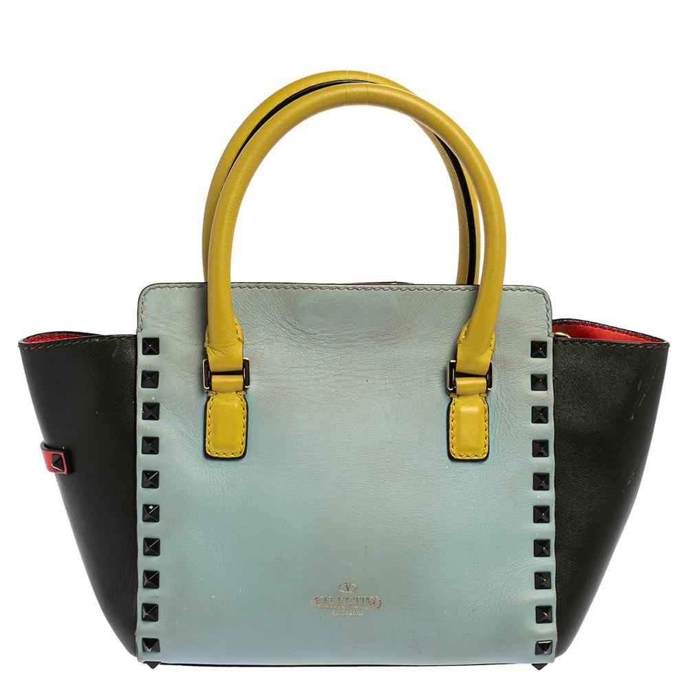 Valentino brings you this super-stylish tote cast in a design that transcends trends. It has a multicolor leather exterior decorated with signature Rockstuds. The tote is complete with a leather interior, two top handles, and a shoulder strap meant