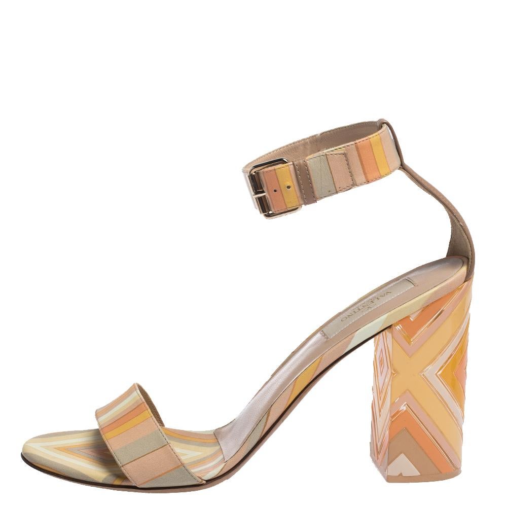 These unique sandals come from the iconic house of Valentino. Crafted meticulously in Italy, they are made from quality leather and plexiglass. They come in multicolored hues and feature a 'Native Couture 1975' print that adds glamour. They are