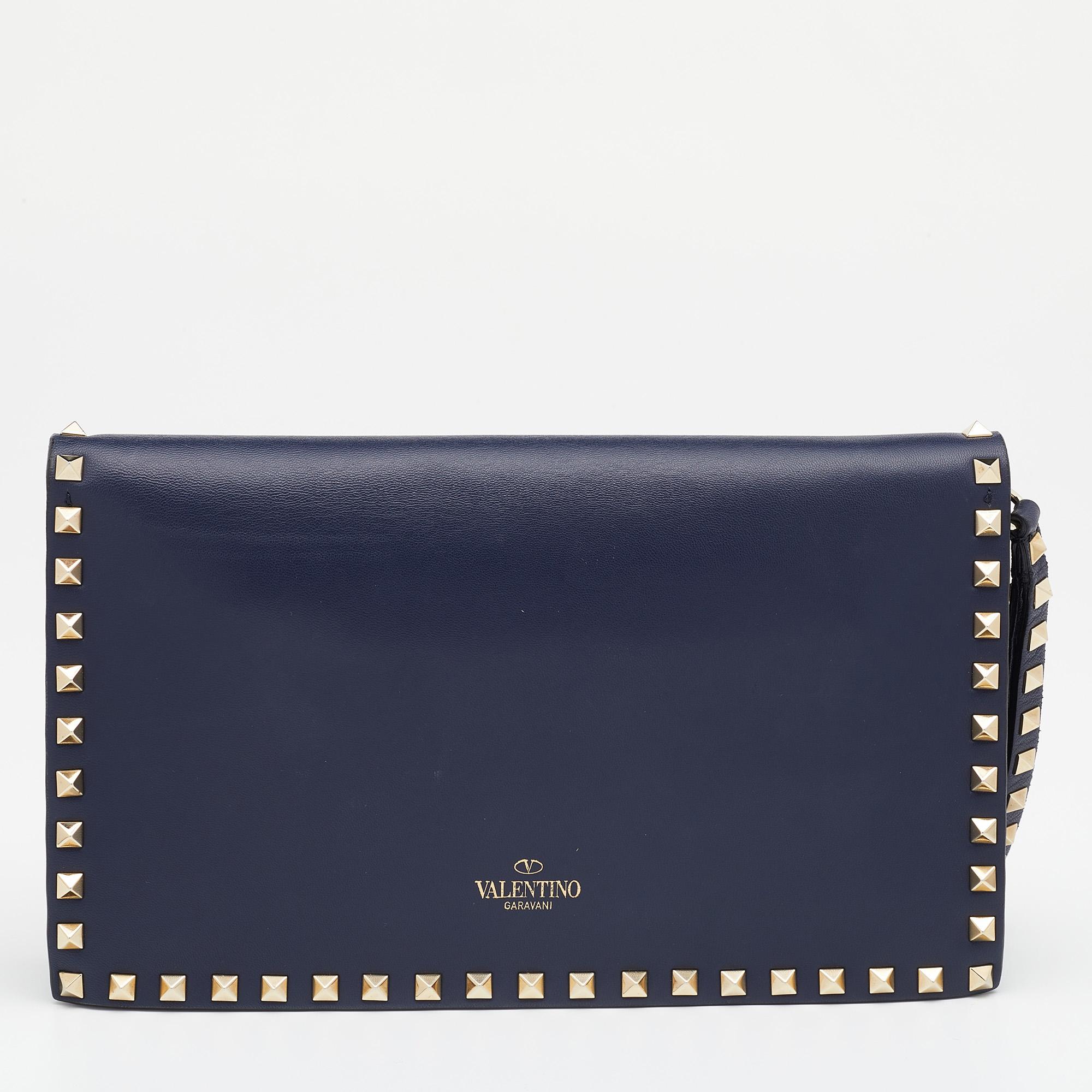 Very stylish and well-made, this black clutch by Valentino will offer you the signature aesthetics of the brand. Crafted from leather, the clutch is styled with a wristlet and adorned with the signature Rockstud accents on the exterior. It opens to