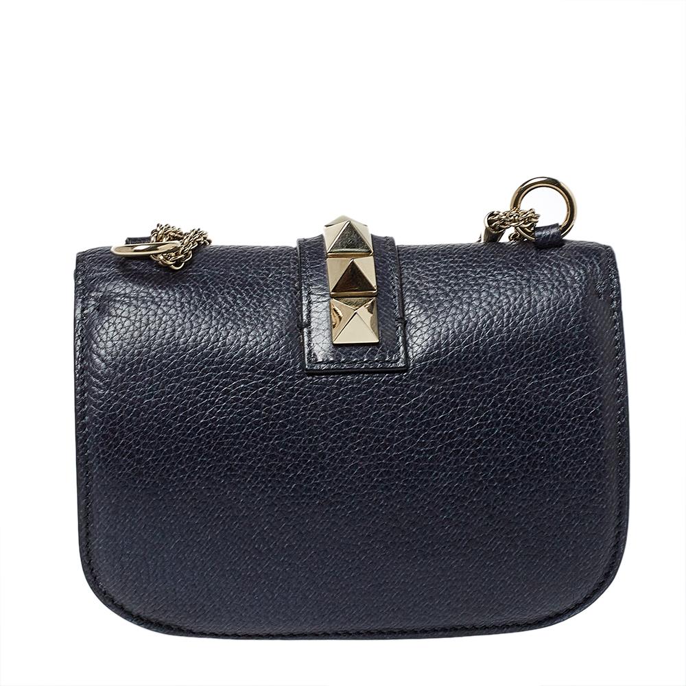 If you are looking for a bag with a blend of modern style and class, this Valentino creation is the answer. Crafted from leather, this navy blue piece comes with a gold-tone chain and a flap with a push-lock to secure the well-sized suede interior.