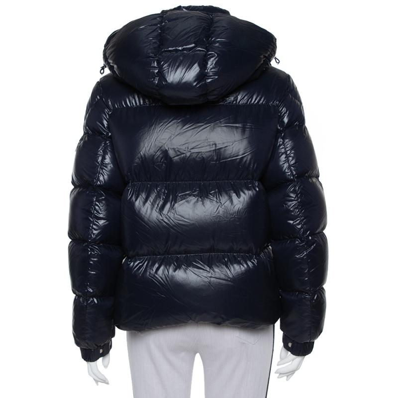 This padded jacket has been designed by Valentino to accompany you all day long. Made from quality materials, the navy blue jacket promises comfort and high-fashion. It features a zip and button closure, two pockets, a hood, and the VLOGO in red on