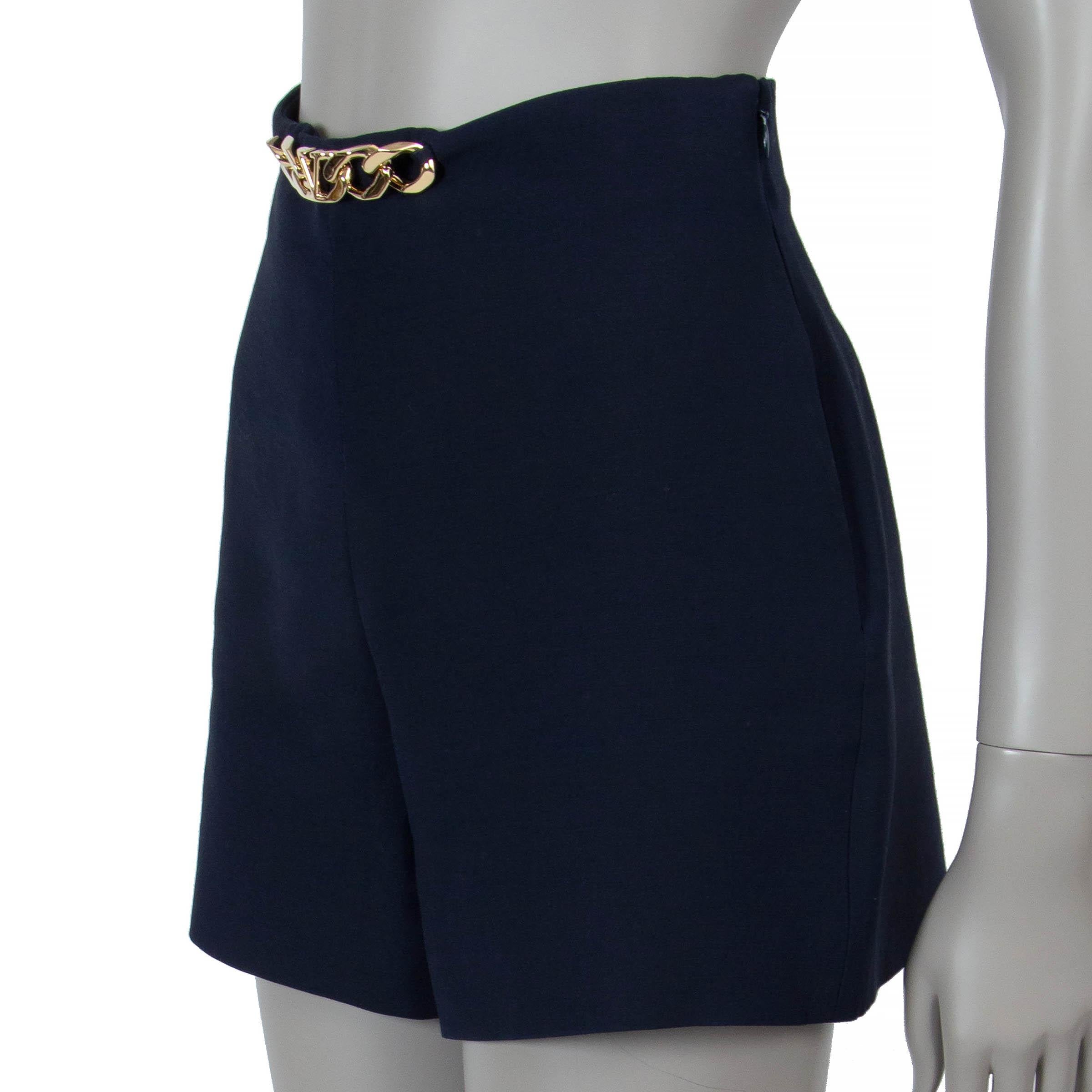 These 100% authentic Valentino shorts in navy blue crepe wool (65%) and silk (35% - please note the content and size tag are missing) offer a chic, tailored silhouette. Designed with a high waist and mini length, they are adorned with a gold-tone