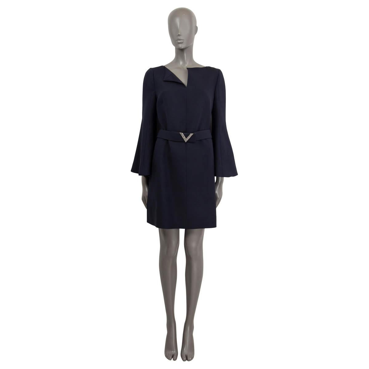 100% authentic Valentino logo belted a-line dress with bell sleeves in navy blue virgin wool (65%) and silk twill (35%). The design features a waist belt with the V logo embellished with grey rhinestones, two slit side pockets and opens with a