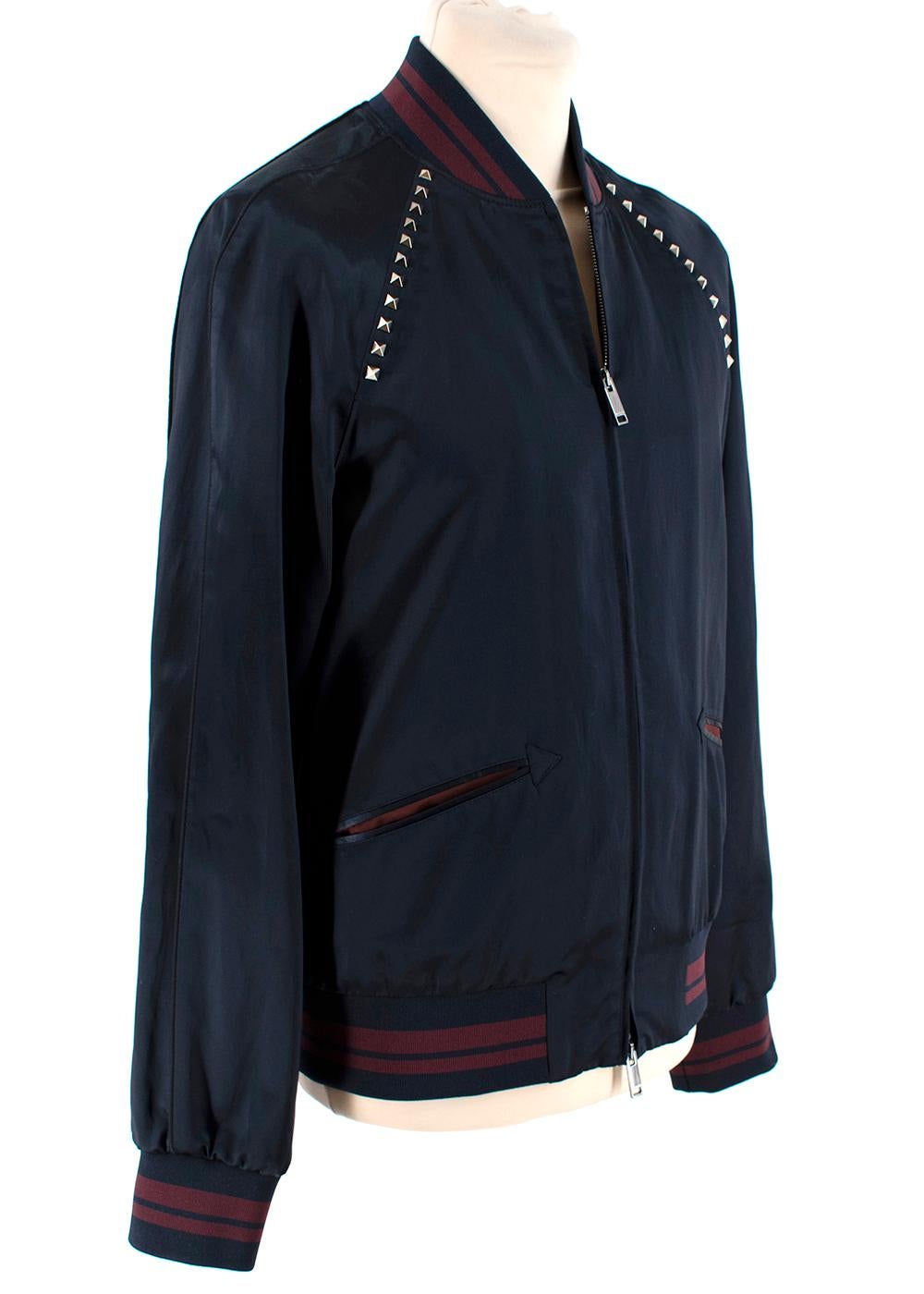 Valentino Rockstud Bomber Jacket 

- Made of soft satin 
- Classic bomber style 
- Neutral navy hue 
- Burgundy striped details
- Ribbed cuffs and hem 
- Signature rockstud details 
- Zip fastening to the front 
- Elegant versatile design