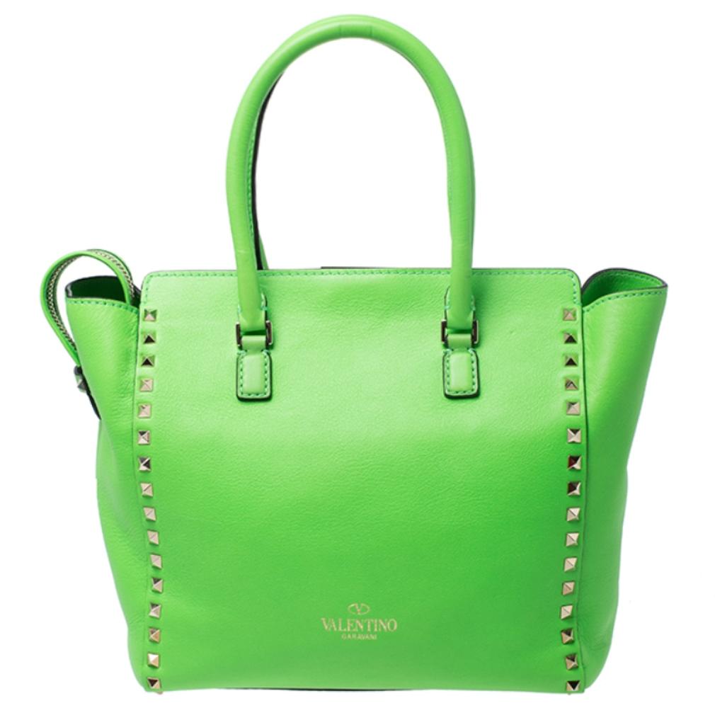 Valentino brings you this super-stylish tote that carries a design which will surely grab the attention of your onlookers. It has a green leather exterior decorated with the signature pyramid Rockstuds. The tote is complete with a spacious fabric