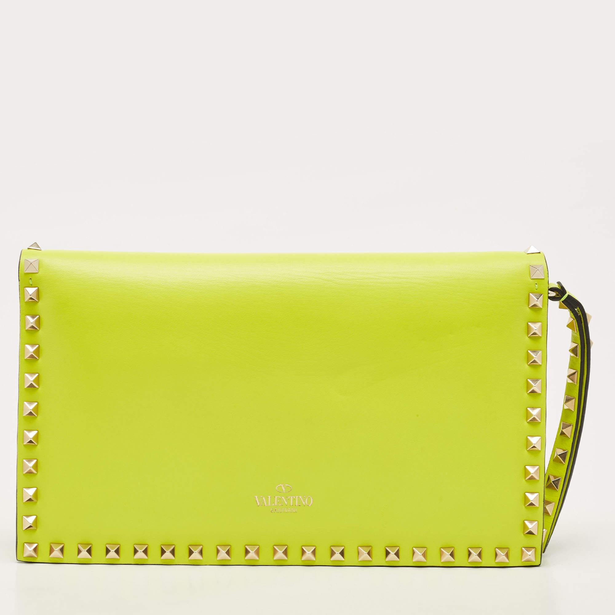The Valentino clutch is a vibrant and stylish accessory. Crafted from high-quality neon yellow leather, it features the iconic Rockstud detailing and a convenient wristlet strap. The flap closure adds a touch of elegance, making it perfect for any