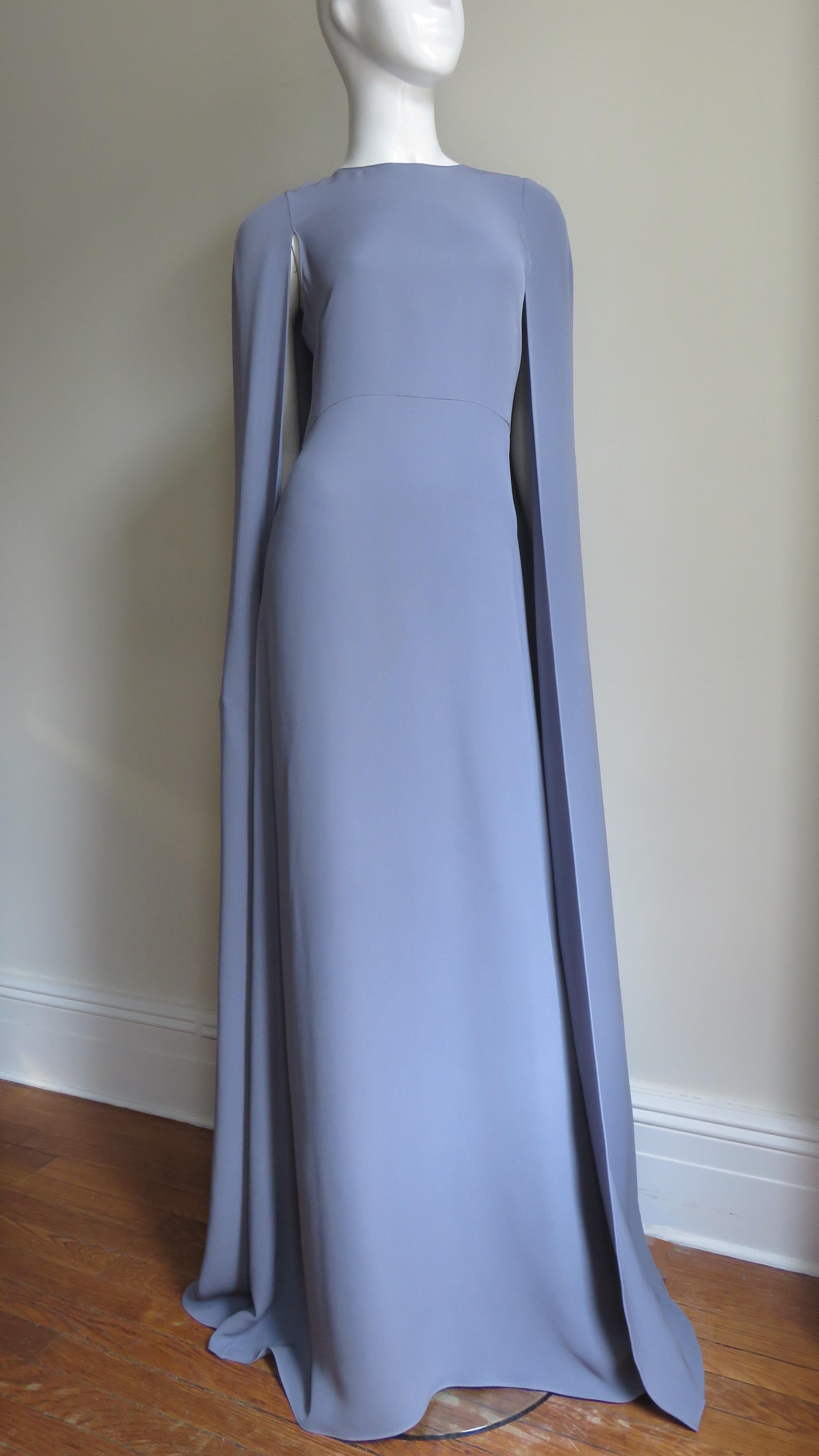 A gorgeous lilac silk gown dress from Valentino.  It is semi fitted, sleeveless with a crew neckline and a fabulous long cape falling from the shoulders and back the length of the dress.  It is unlined, has a back zipper in the dress portion and a