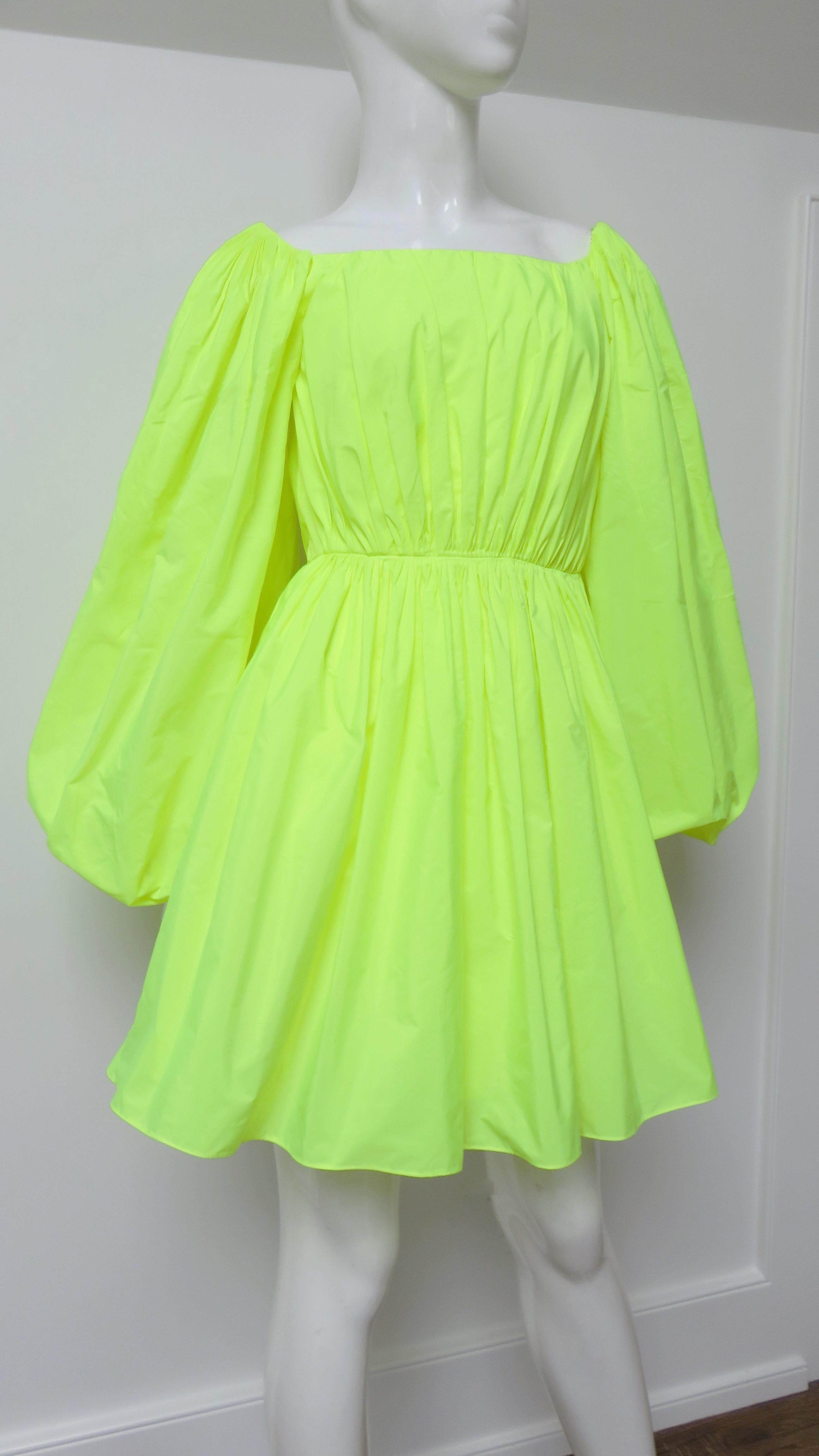 An incredible neon dress from Valentino.  It has a scoop neckline, full sleeves, a full skirt, and a fitted waist. It is lined in the same fabric and has a back zipper.  
Fits sizes Small, Medium. Marked Italian size 38.

Bust  36