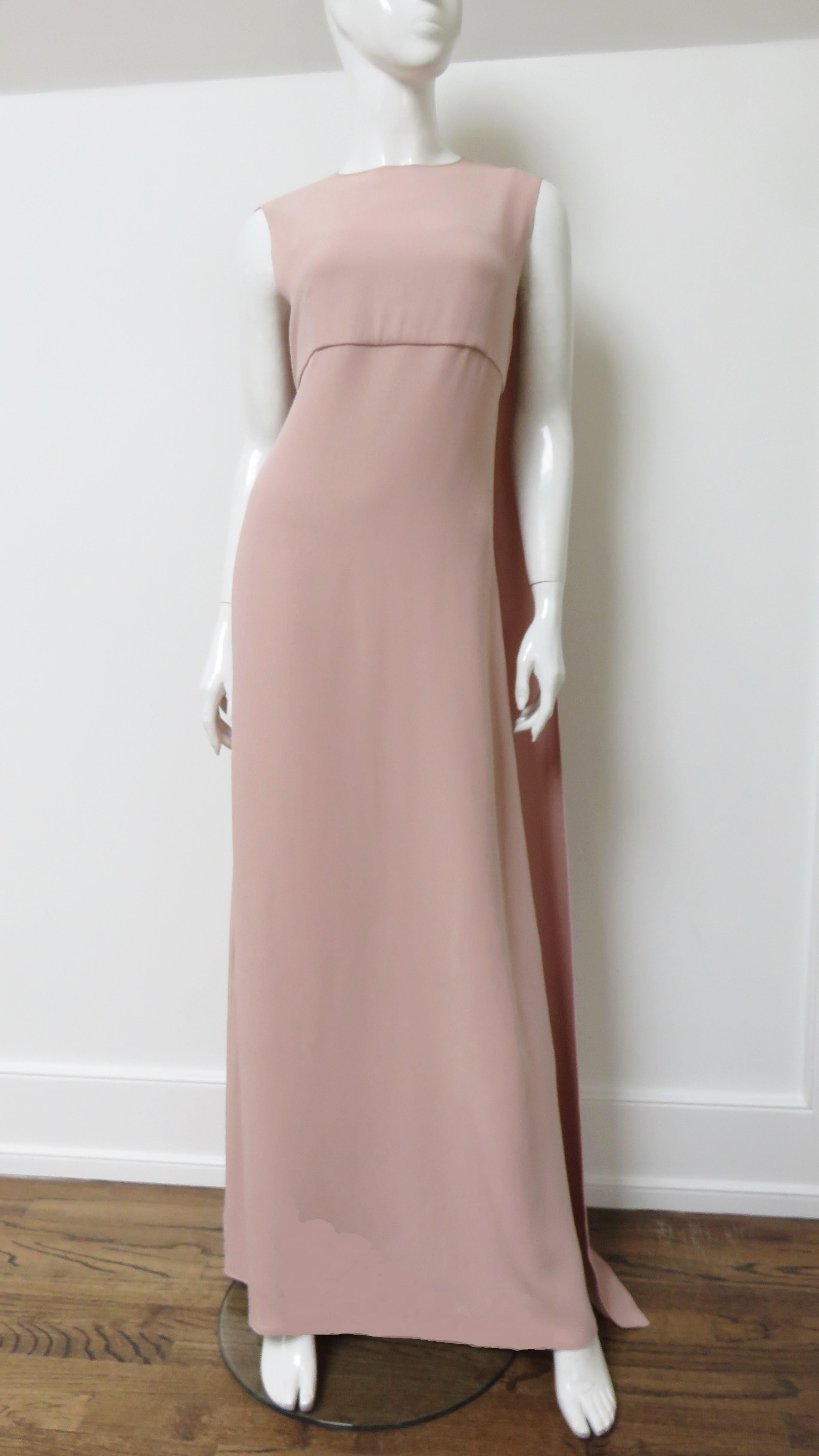 A fabulous pink silk cape dress from Valentino.  It is a sleeveless body skimming dress with a panel draping over the shoulders forming a cape in the back. The bust is lined in the same fabric, the dress portion under the cape has a matching back