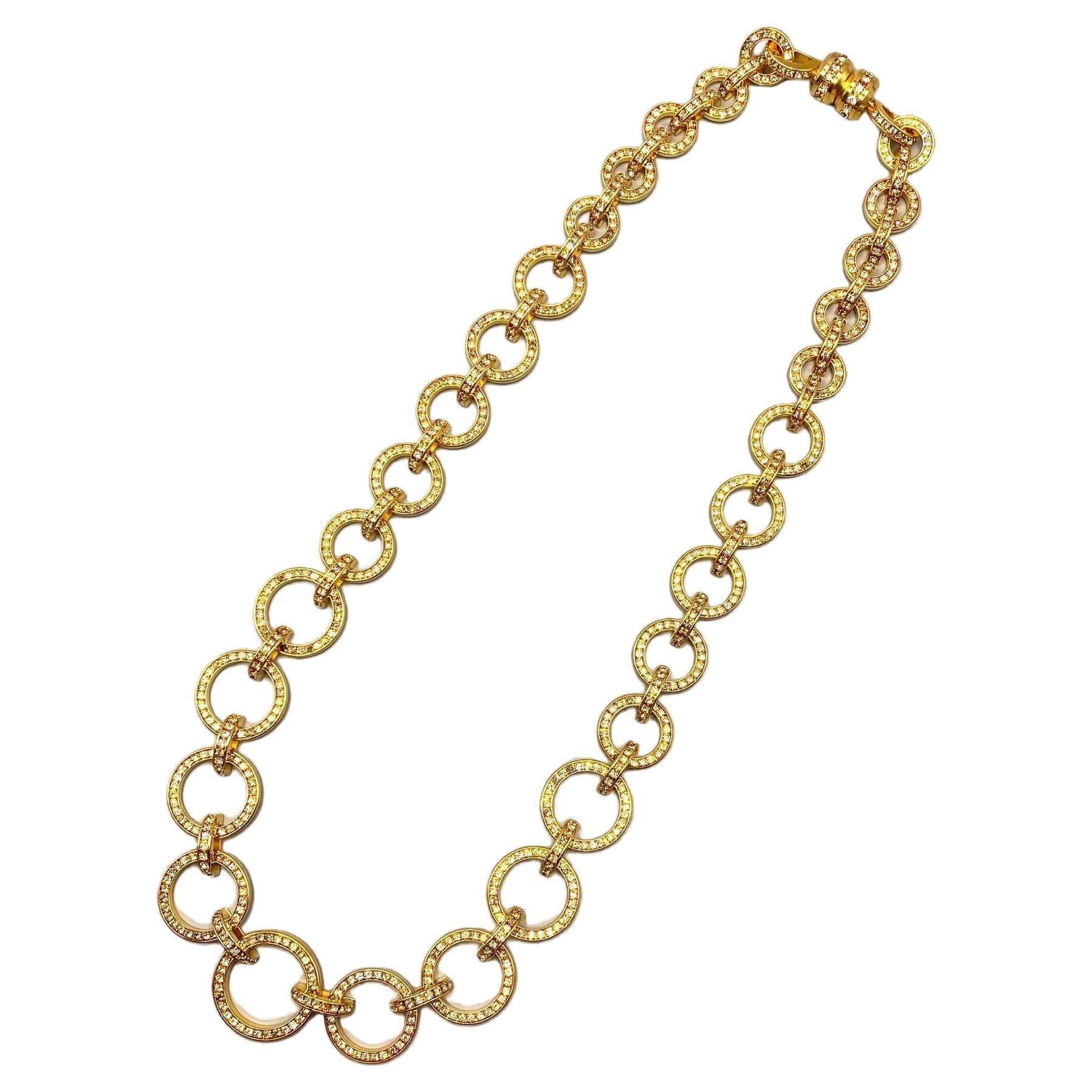A lovely eye catching gold and rhinestone set long necklace by Valentino Garavani of Italy. The necklace is graduated with the smallest ring links .75 of an inch in diameter up to the largest ring at the bottom center of 1.38 inches in diameter. The
