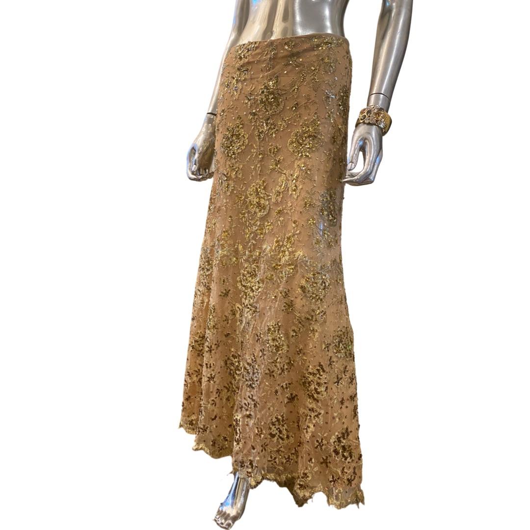 This skirt is so chic! The hand beaded detail on the lace is so intricate. The lace has metallic gold thread for depth and a 3D effect. Nude color chiffon lining. Simple waist detail (no waistband) It has a center back zip. Made in Italy, this skirt