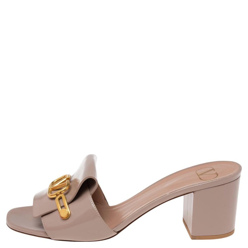 We're greatly impressed by these mule sandals from Valentino! They are crafted from leather and styled in an open-toe silhouette with the signature VLogo accents on the vamp straps. Comfortable leather-lined insoles and 6 cm block heels complete