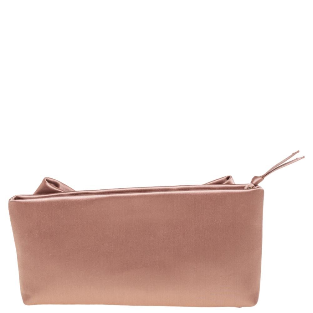 This clutch by Valentino is what you would carry on an evening out. The luxurious satin exterior is simply detailed with a lovely oversized bow and a top zip closure. The satin interior will easily hold your little essentials. Grab this nude pink