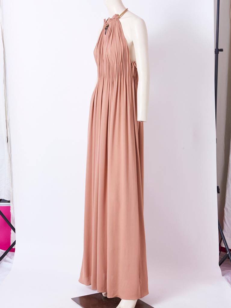 Valentino, nude tone, silk jersey, delphos, inspired maxi dress, having a halter neckline, with an attached neck piece in bronze tone metals inspired by African sculpture. The maxi length dress has subtle natural pleating, starting at the neck ,