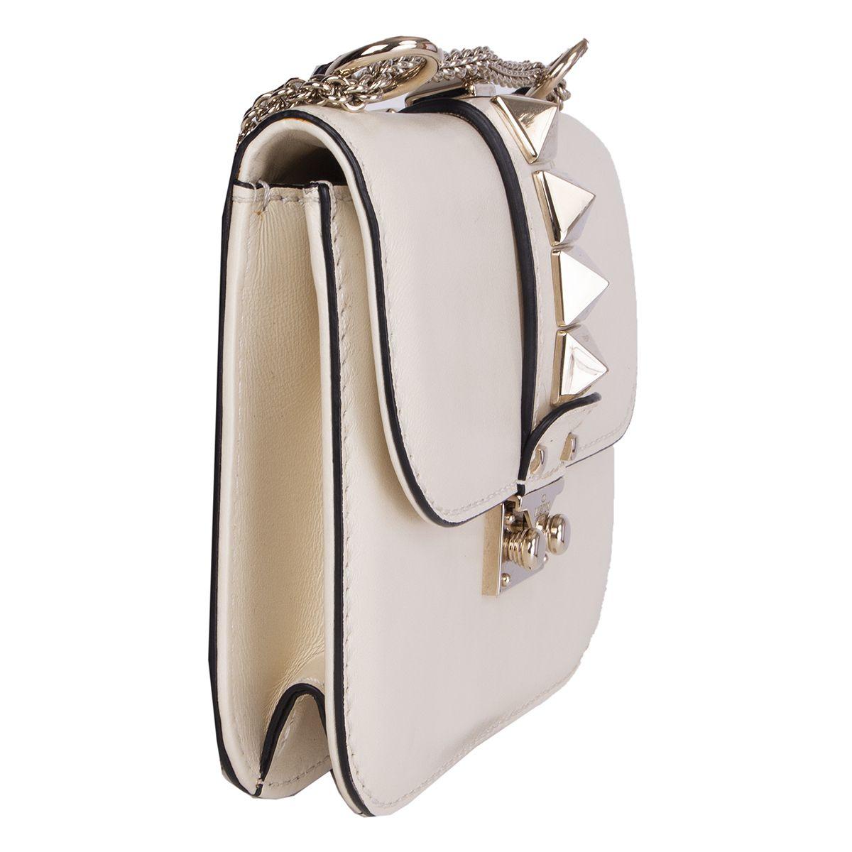 Valentino 'Small Lock' chain shoulder bag in off-white smooth calfskin featuring light gold-tone ruthenium finish metal studs. Opens with a tuck catch closure with engraved logo. Lined in beige canvas with one zip pocket against the back and one