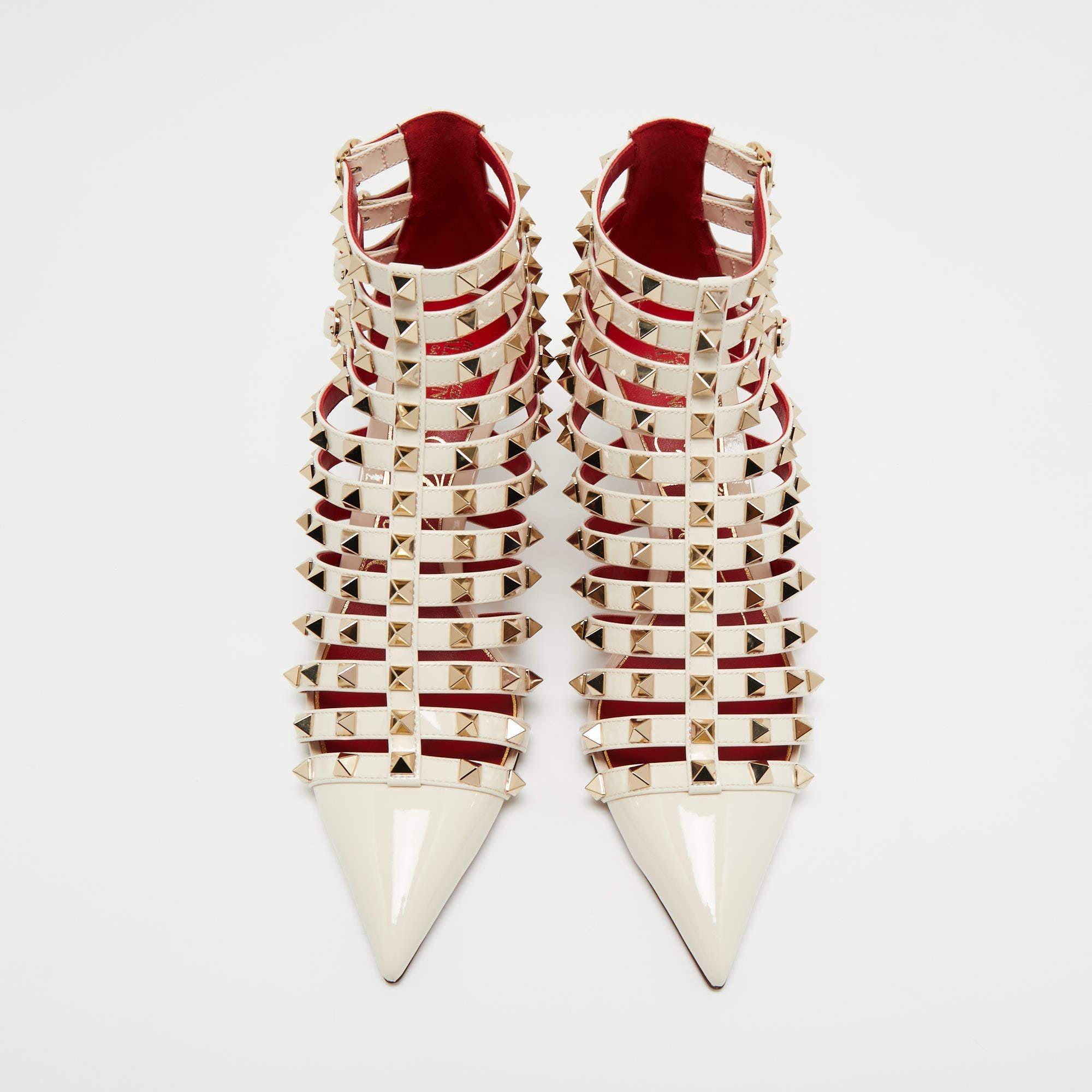 Valentino's Alcove ankle booties are presented in off-white patent leather and highlighted by the brand's signature Rockstud design on the exterior. The shoes are mounted on low heels.

 Includes: Extra Heel Tips, Original Box, Original Dustbag,
