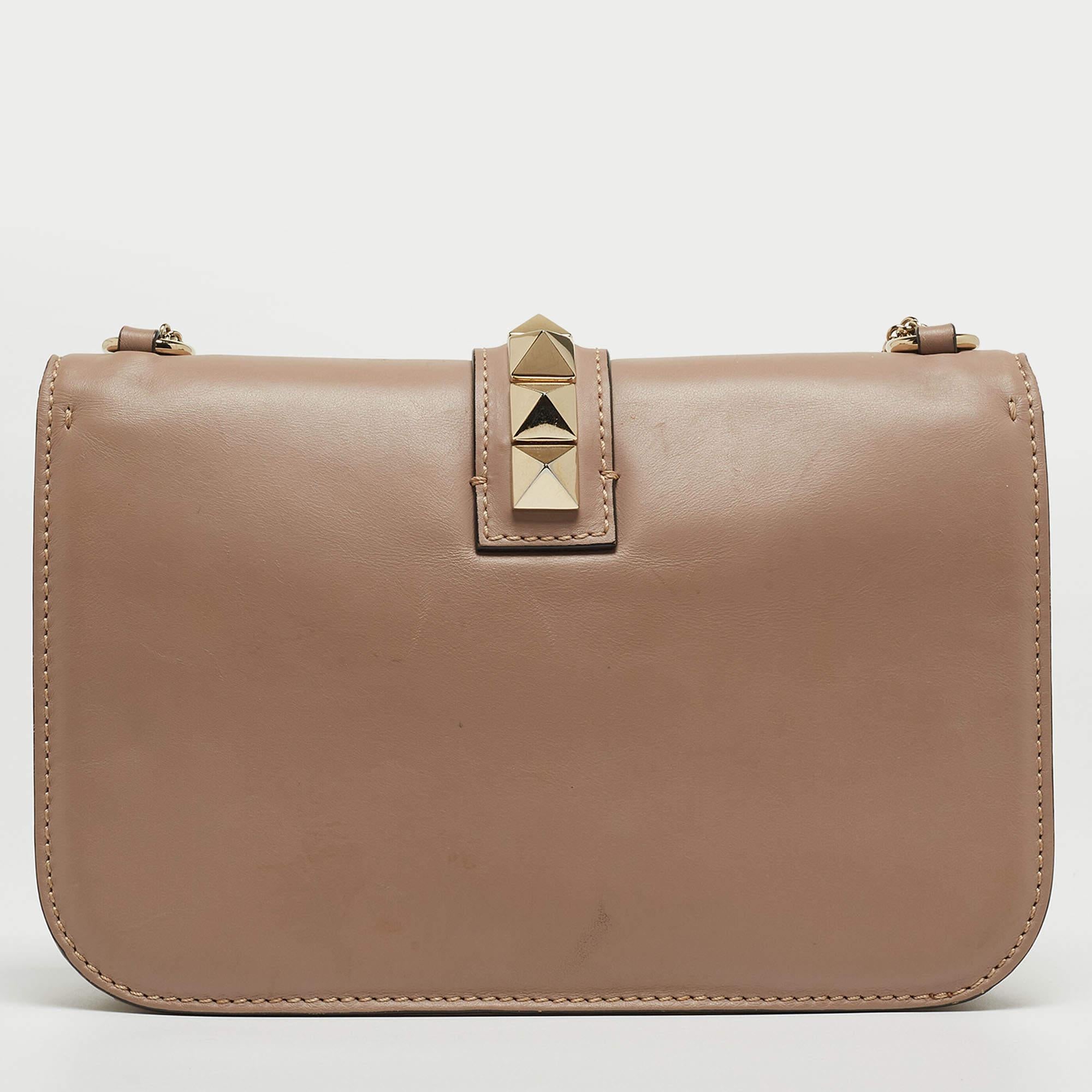 Célébrant le riche héritage de la marque, ce sac Valentino est décoré de Rockstuds. Il est fabriqué en cuir et présente un design remarquable. Doublé de tissu, il est sécurisé par une fermeture verrouillée de la marque sur le rabat avant. La
