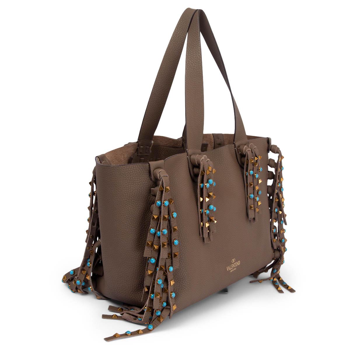 100% authentic Valentino C-Rockee fringe tote in grained olive drab calfskin embellished with signature pyramid studs in copper metal and turquoise cabochon stones. Lined in olive drab suede with two big zipper pockets. Has been carried and is in