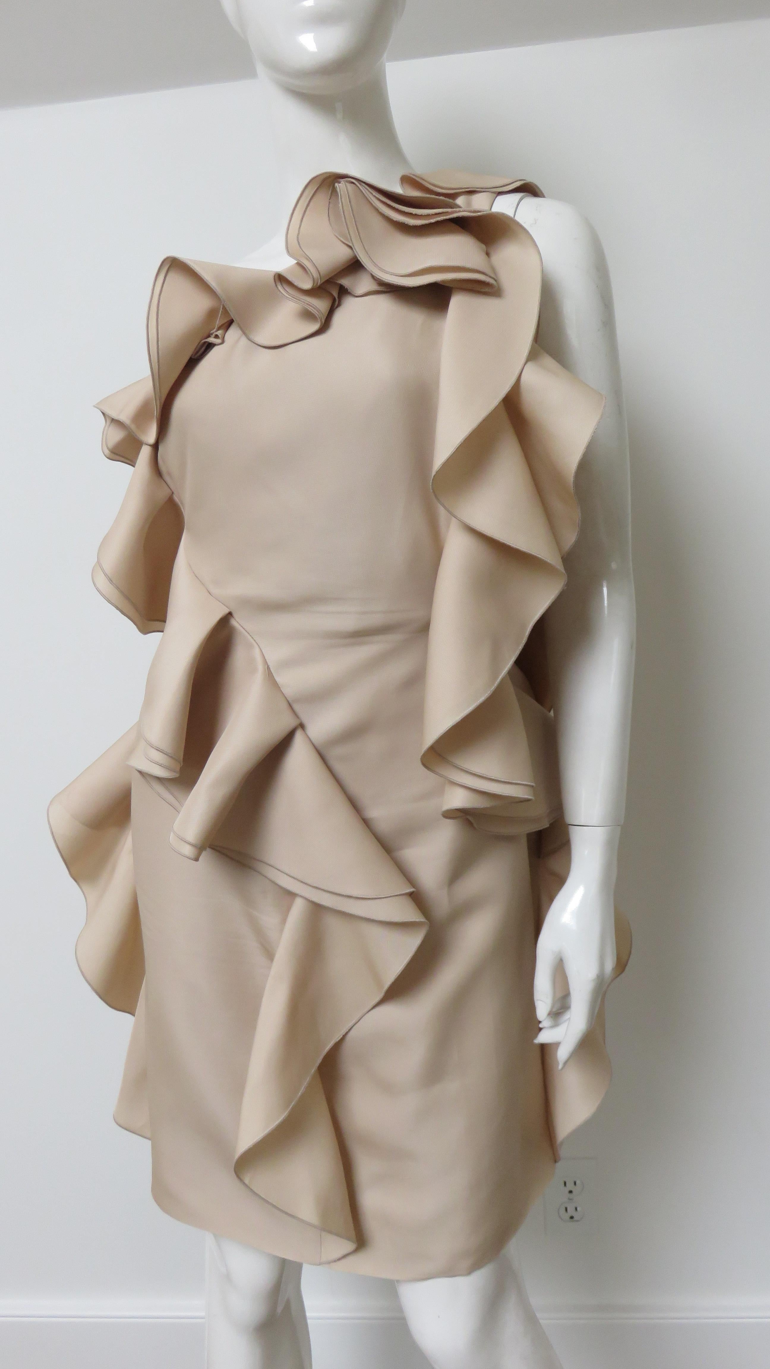 Un precioso vestido de seda nude de Valentino. Hileras de volantes degradados adornan el cuello, los laterales y en diagonal por delante y por detrás.  Tiene una cremallera lateral y está forrado de seda a juego.
Se adapta a las tallas Mediana y