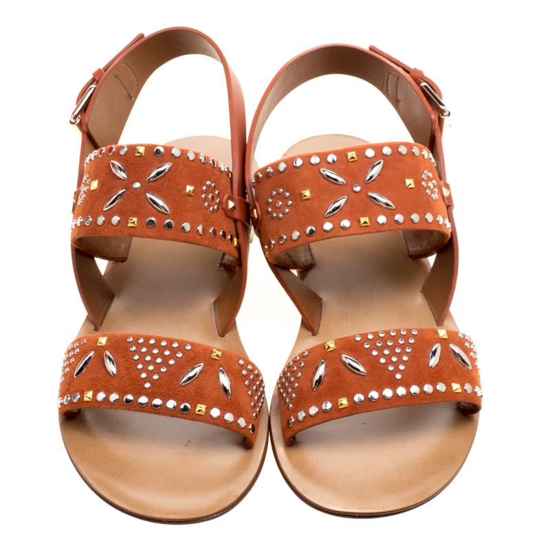 These comfortable and stylish flat sandals from Valentino are perfect to pair lounge in and go well with your casual wear. The orange suede sandals have embellished vamps and quarter straps. Silver and gold tone studs and sequins detailing adds a